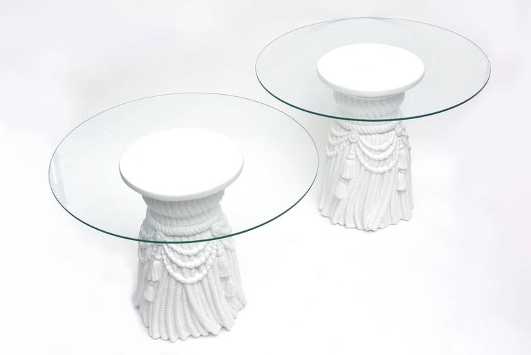These wonderful John Dickinson style plaster of Paris small white tasseled and draped sculptural side tables have glass tops. They really can standalone without the glass tops or very heavy circular glass tops smaller can be made at your end. They