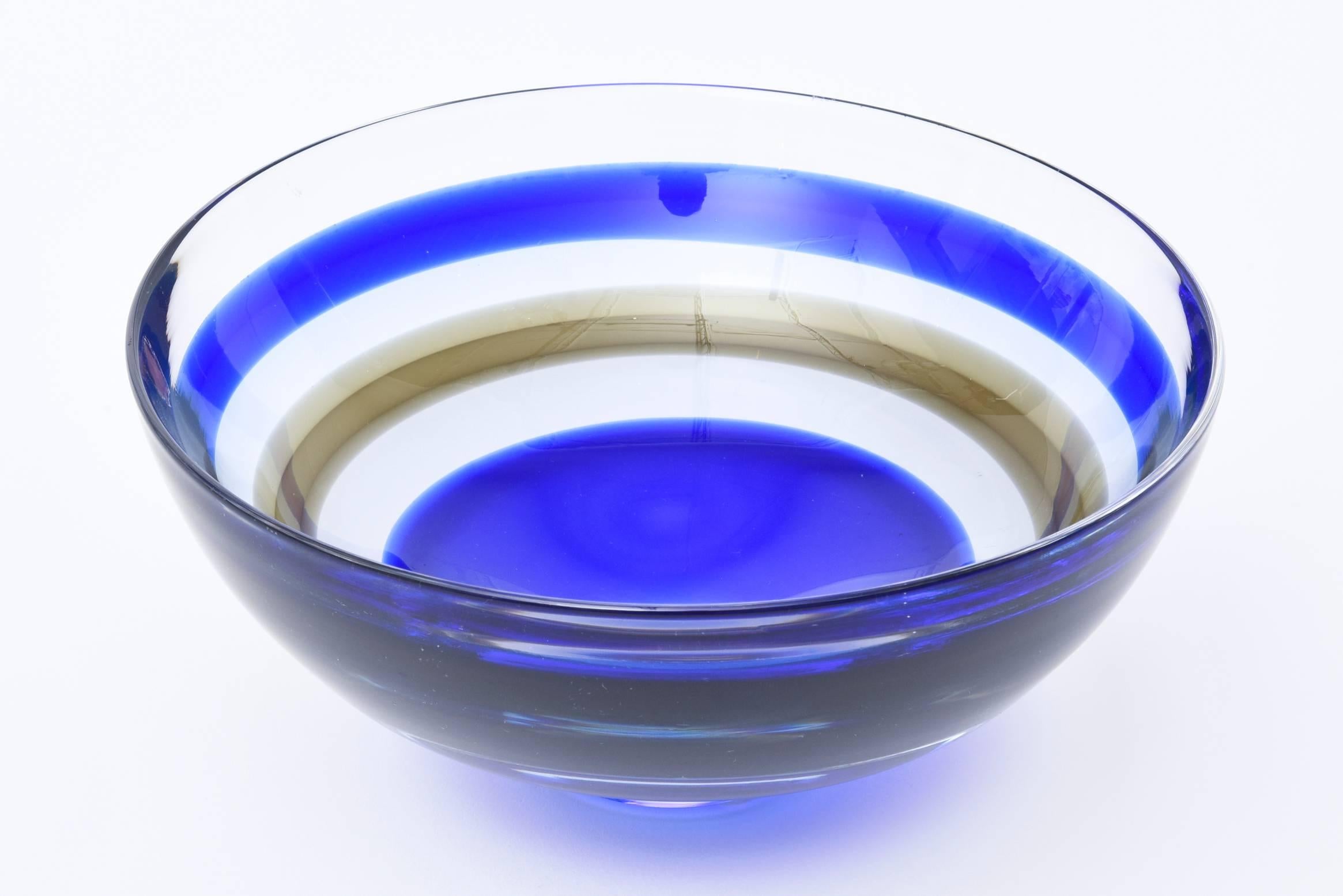 This stunning and vibrant cobalt blue and sage brown striped banded glass Swedish Orrefors vintage crystal glass bowl has the original sticker on it from the time of the 1960s. This is a beauty. There is one brown sage stripe admidst the cobalt