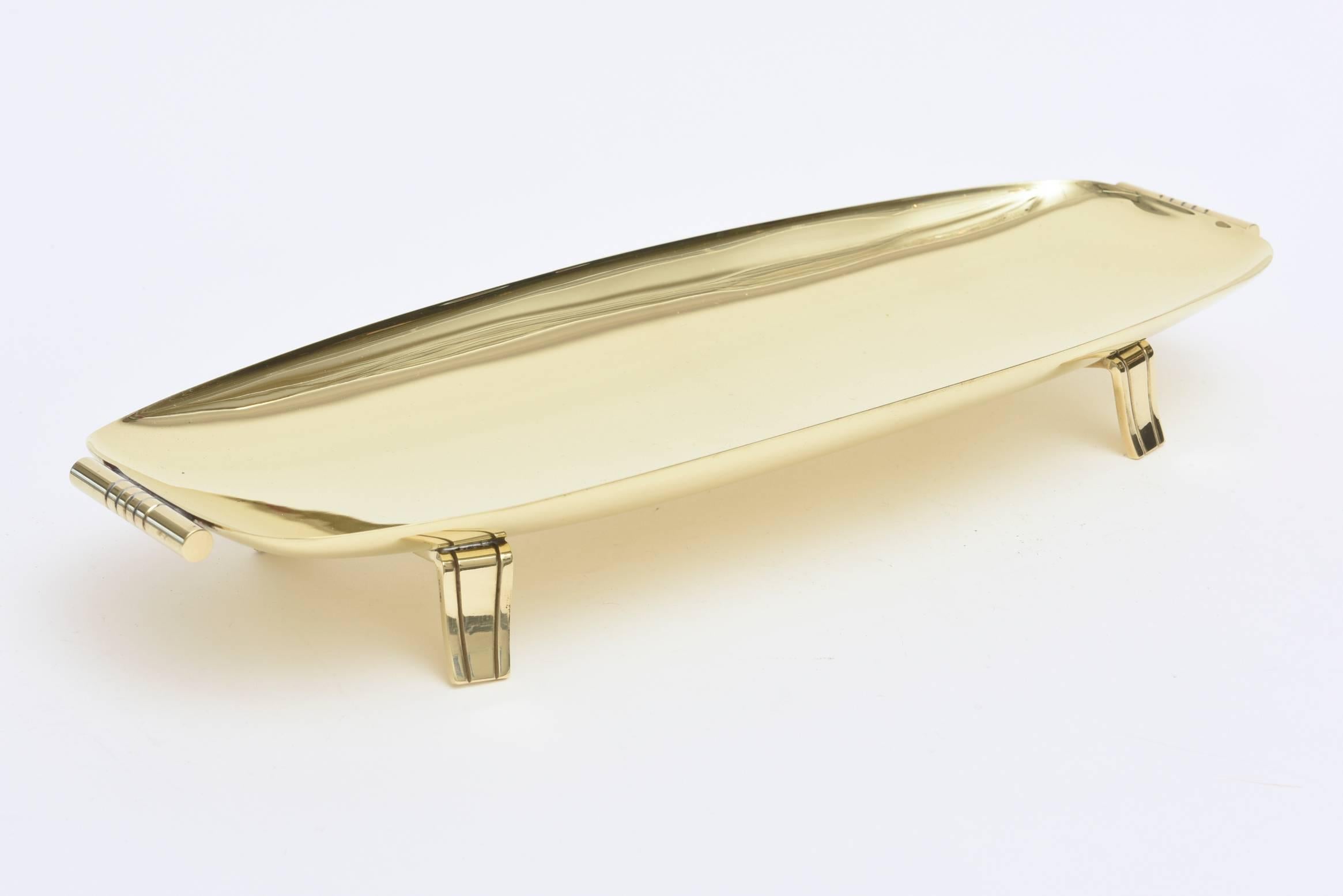 This great Mid-Century Modern Tommi Parzinger polished brass bowl was made by Dorlyn Silversmiths as hallmarked on the bottom. The rolled handles and feet are pure Parzinger. It is elongated rectangle. Timeless! Classic! This is a fabulous bowl and