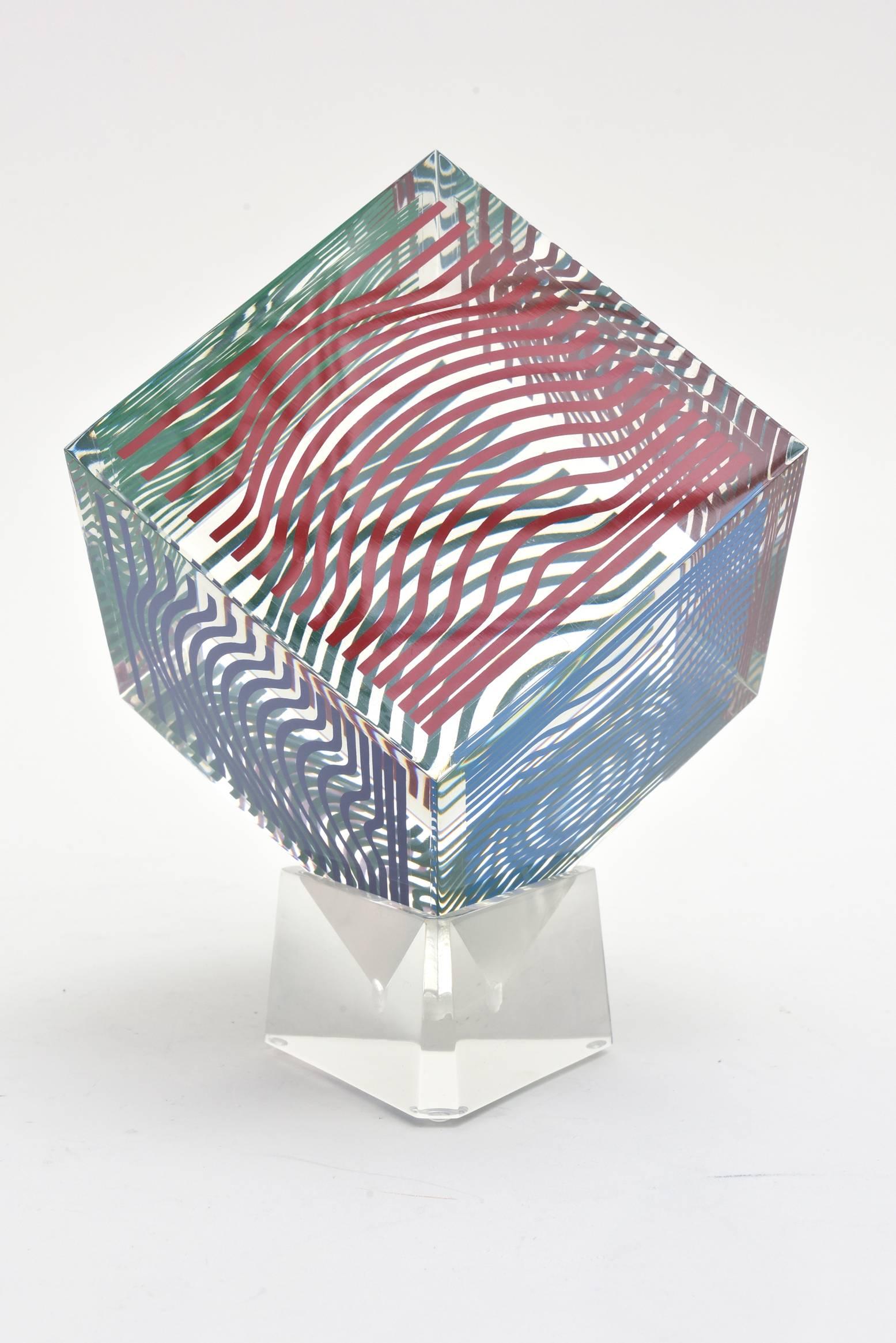 This four sided every changing graphic optical Op Art lucite vintage cube sculpture by Victor Vasarely is vintage from the 1970s. They were produced in a large edition at the time but not numbered. It is a silkscreen acrylic. It is not signed but