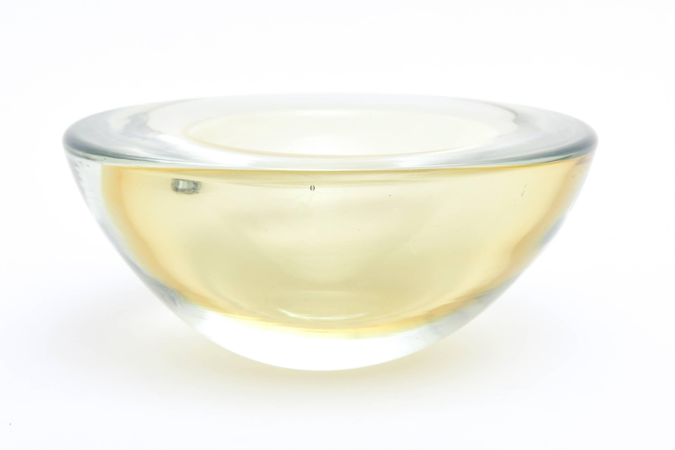 This gorgeous and thick walled heavy Sommerso Italian Murano geode glass bowl is large. It is attributed to the work of Seguso. It has radiants of lemon Cello to an iridescent very light green to a light amber yellow green all in Sommerso color. It