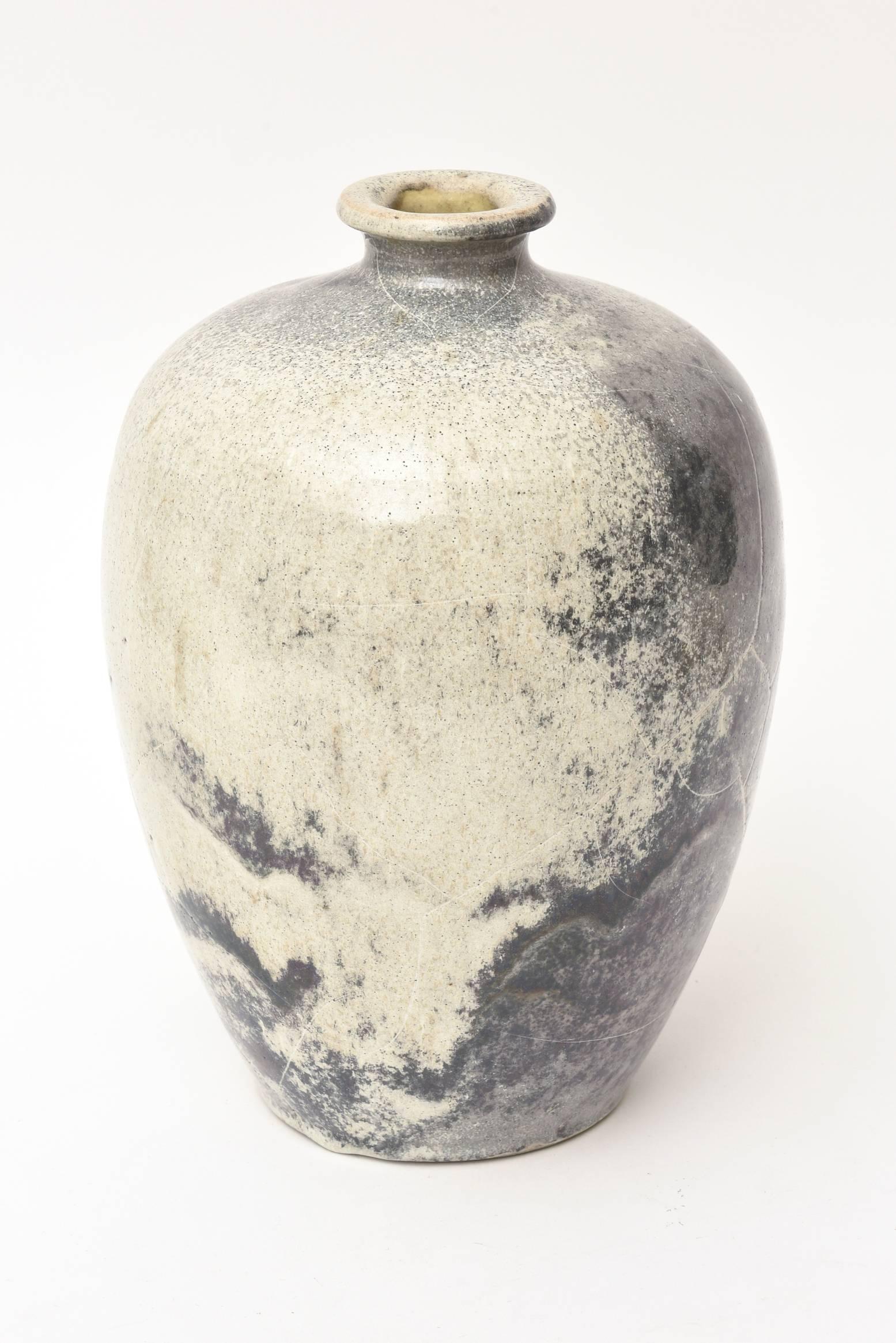 This modernist Mid-Century ceramic vase or vessel that is West German has partial labels on it that say Kunsta with parentheses. We are still doing the research. This is a beauty.
The mottled coloring of gray and off white and design now is very