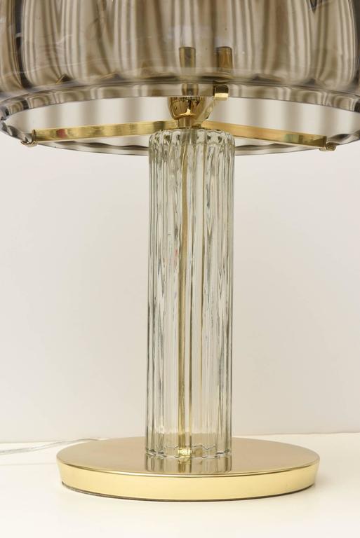 This stunning and unusual Italian Murano vintage Vistosi table or desk lamp has ribbed gradiated smoked glass as the dome shade. It graduates in color from dark shades of charcoal to lighter shades depending on how the light hits and the bulb. The