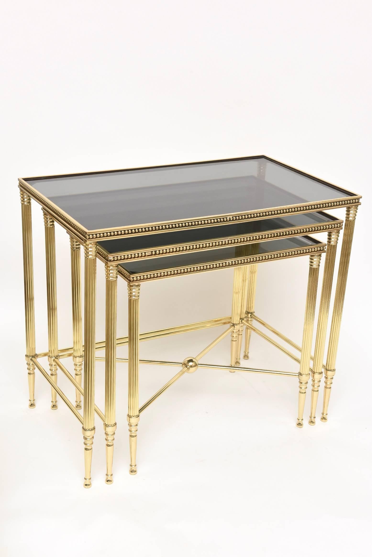These Classic and elegant solid brass nesting tables are from the 1950s and are Italian and stamped as such. The solid brass has been gloriously polished professionally. They are very much in the style of Maison Bagues. The fluted column legs with