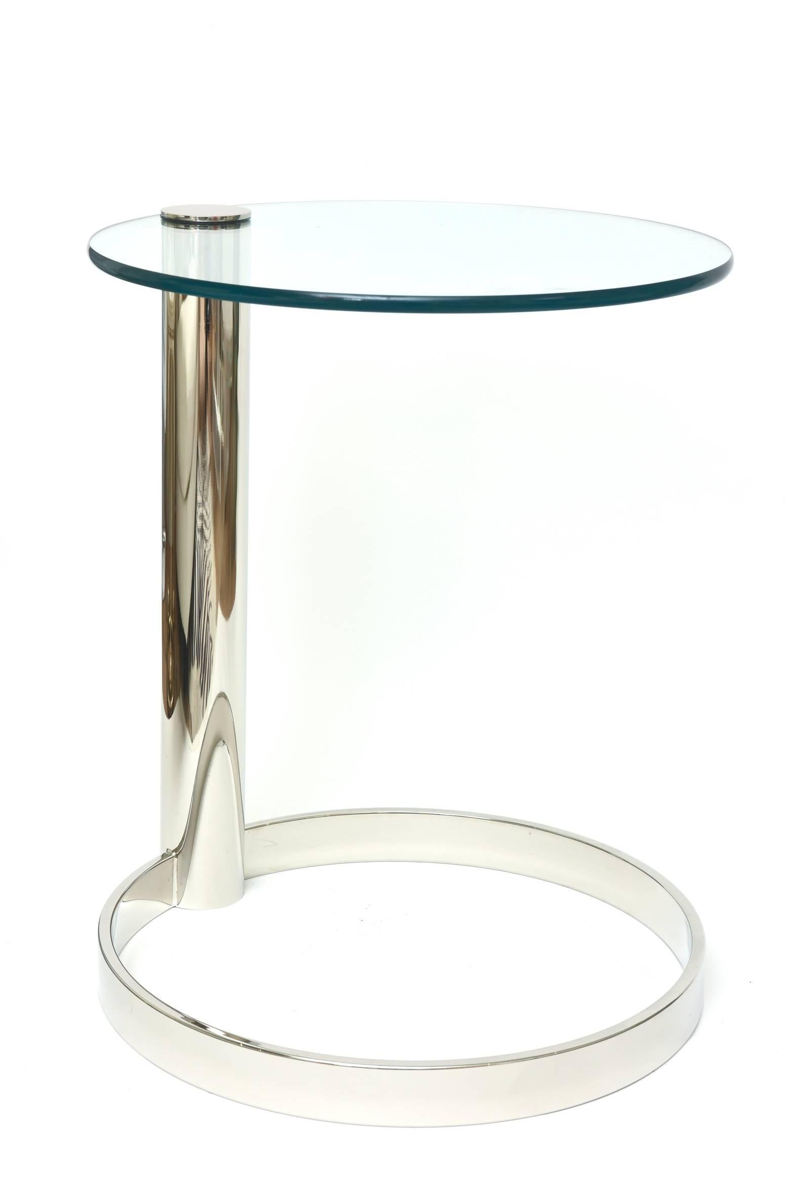 This Classic and modern side table by Leon Rosen for Pace has been beautifully restored with nickel silver over the brass and has a glass top. It is postmodern sculptural. The glass top has a cantilevered swivel top. The nickel silver cap secures