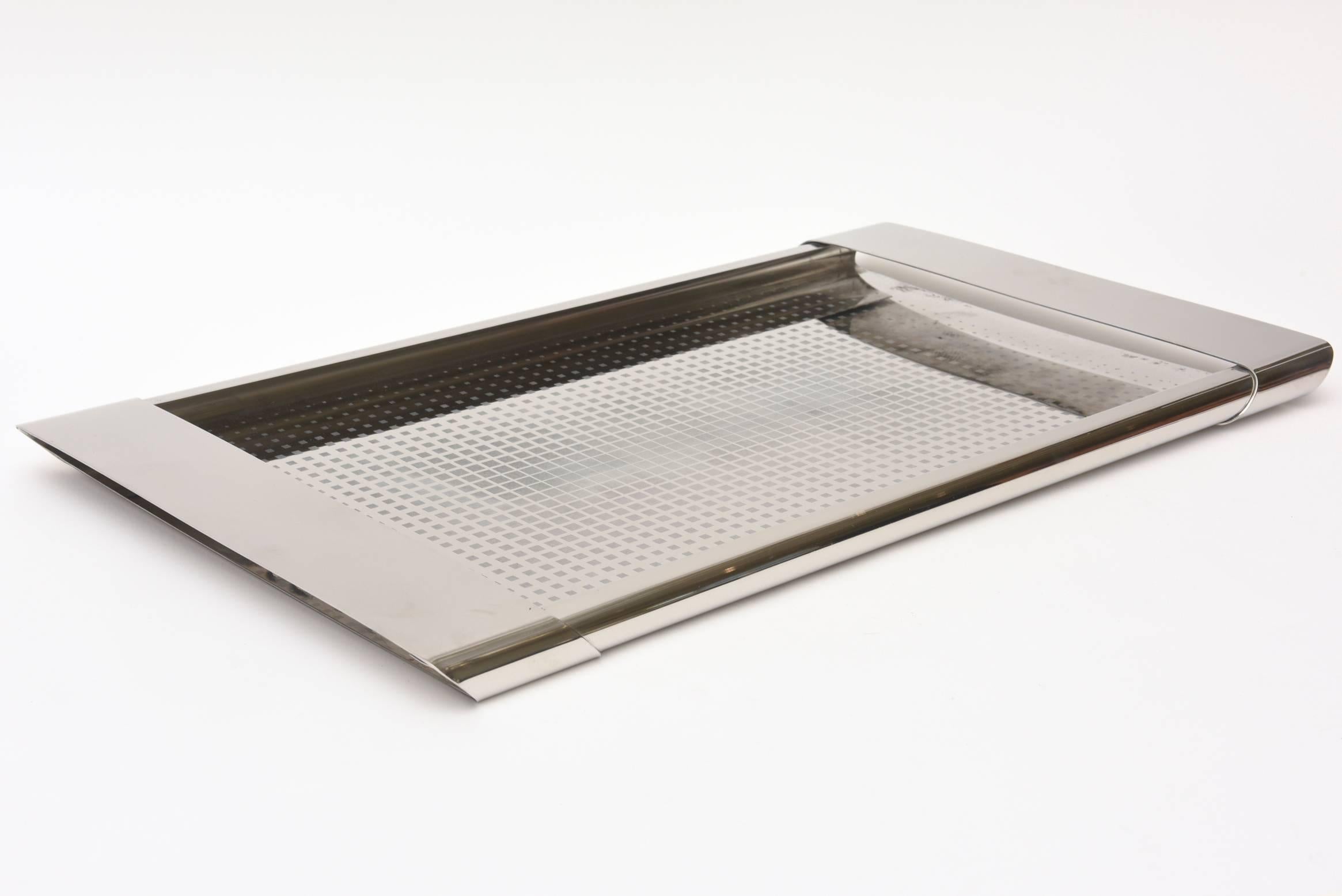 This wonderful long Italian Alessi rectangular tray has a graphic design of repeated graduated small squares in the center portion. It is stainless steel. It is called the Coppolla tray.
Signed Alessi Italia nox 18/10 Coppolla.
It is from the