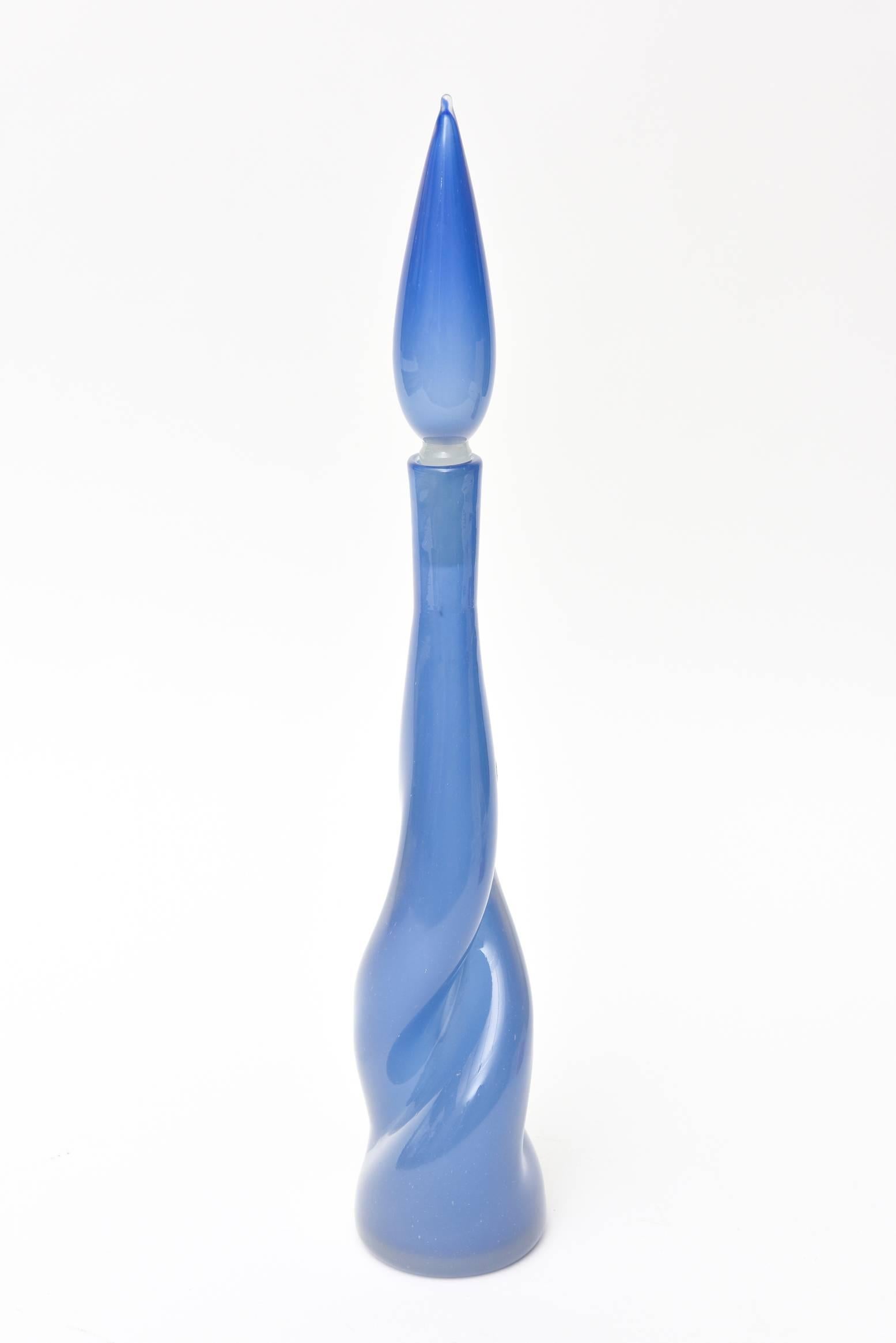 This stunning Italian Murano Archimede Seguso midcentury handblown glass bottle is a most unusual color of periwinkle blue. The hues of periwinkle blue graduate in color and saturation with other forms of blue. It has a twisted sensual form towards