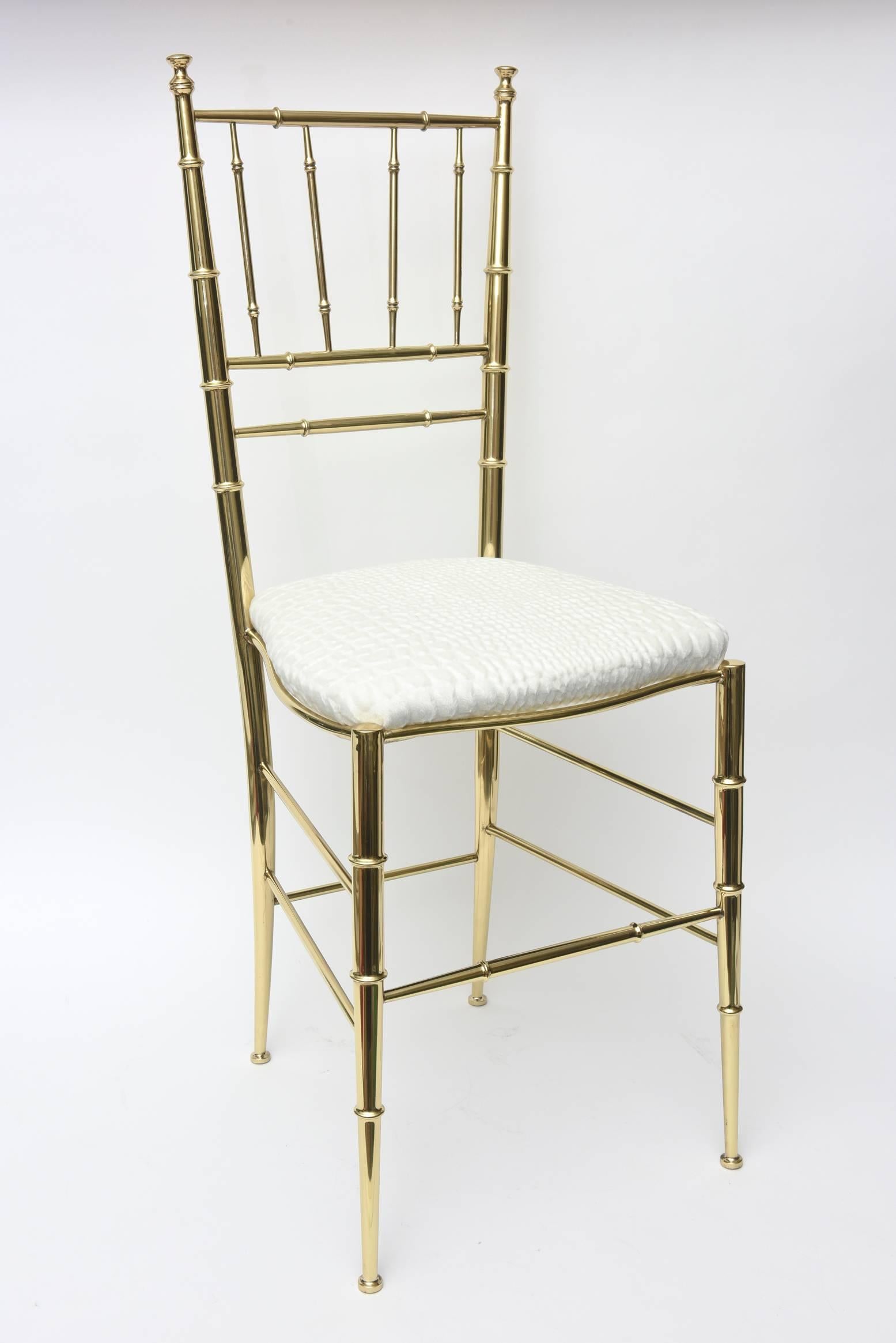 This lovely polished restored brass Italian Mid-Century Modern Chiavari side chair has faux bamboo elements. It has just been re-upholstered in a stunning textural cut velvet crocodile white to off-white upholstery. Tres chic! The brass has been
