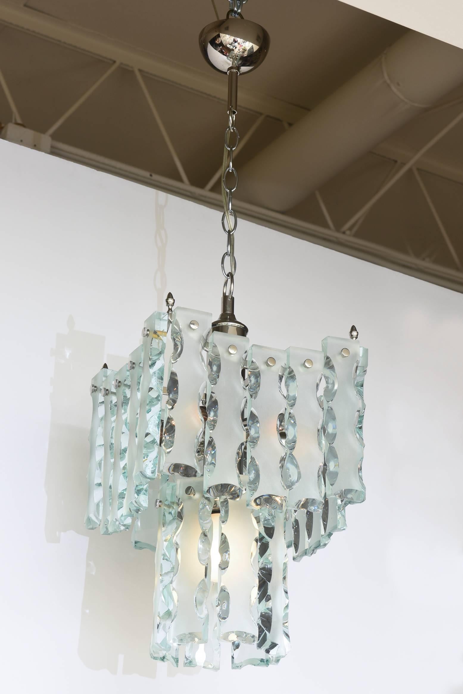 This Mid-Century Modern Murano Italian two-tiered pendant glass and buckle silver caged chandelier has been attributed to Fontana Arte. It has a beautiful elegance to it. The cage has all been re-restored with nickel silver over the original brass