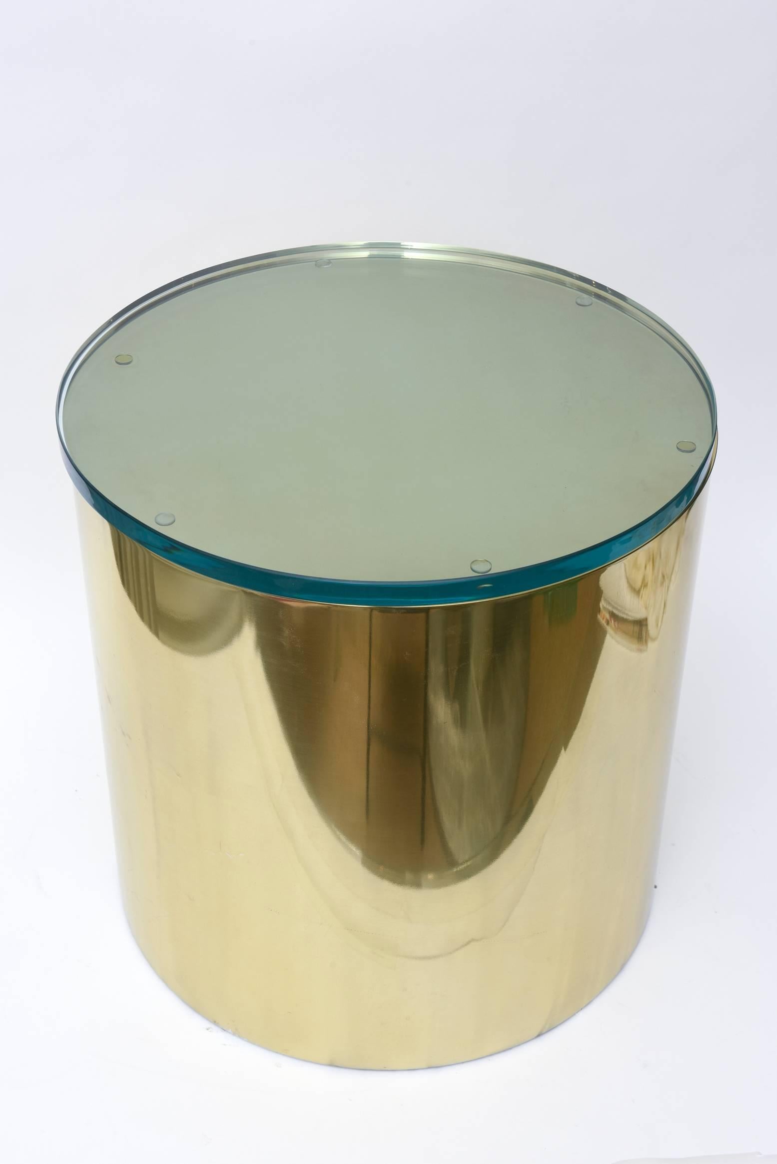 This cylinder round polished brass painted aluminum side drum table has a green glass top attached. It was designed by Paul Mayen for Habitat International. It is signed on the bottom “Architectural Supplements Habitat and Habitat International