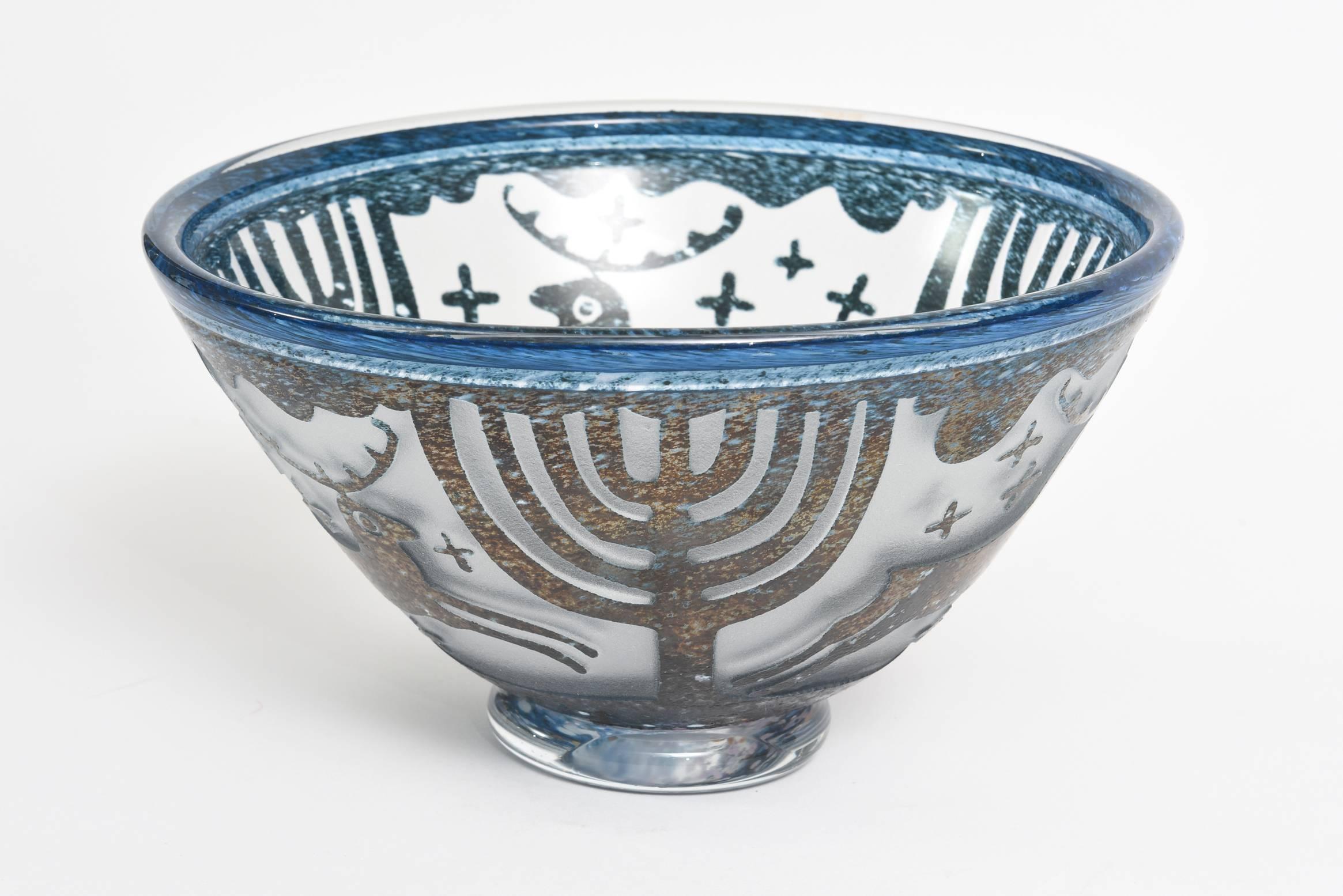 This Swedish Kosta Boda festive glass bowl that is signed Villien is by Ulrica Hydman-Vallienfrom the late 70's. It is textural and the design is raised with an incised intaglio etched process. It is like a relief.  The blues vary in tone and hue