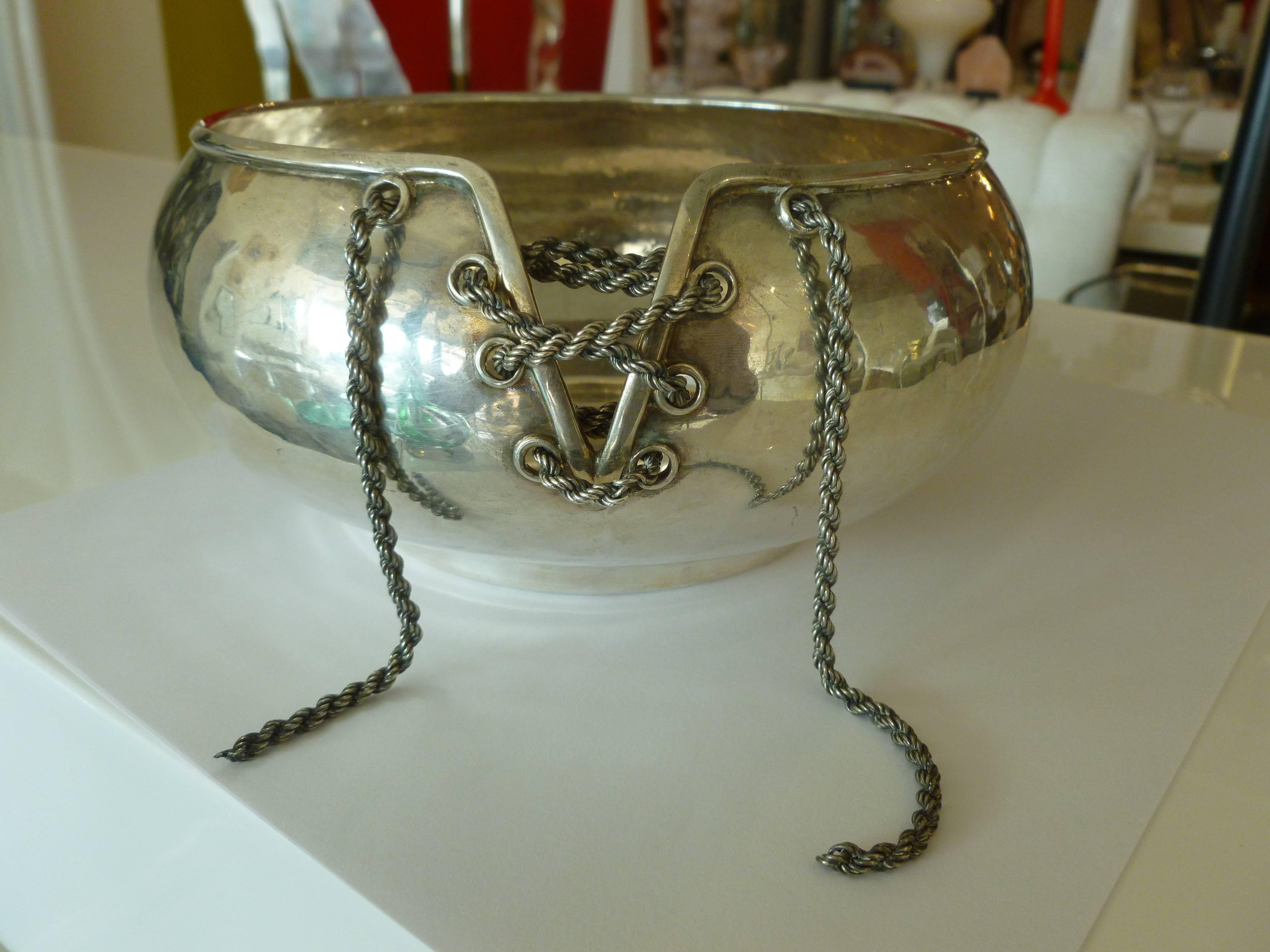This sexy Italian hand-forged silver bowl has a chain corset in the front. The lace up corset is of a chain in silver. This is very Jean Paul Gautier in style.
It can be used for multiple purposes as a bowl or even as a champagne caddy.
it is