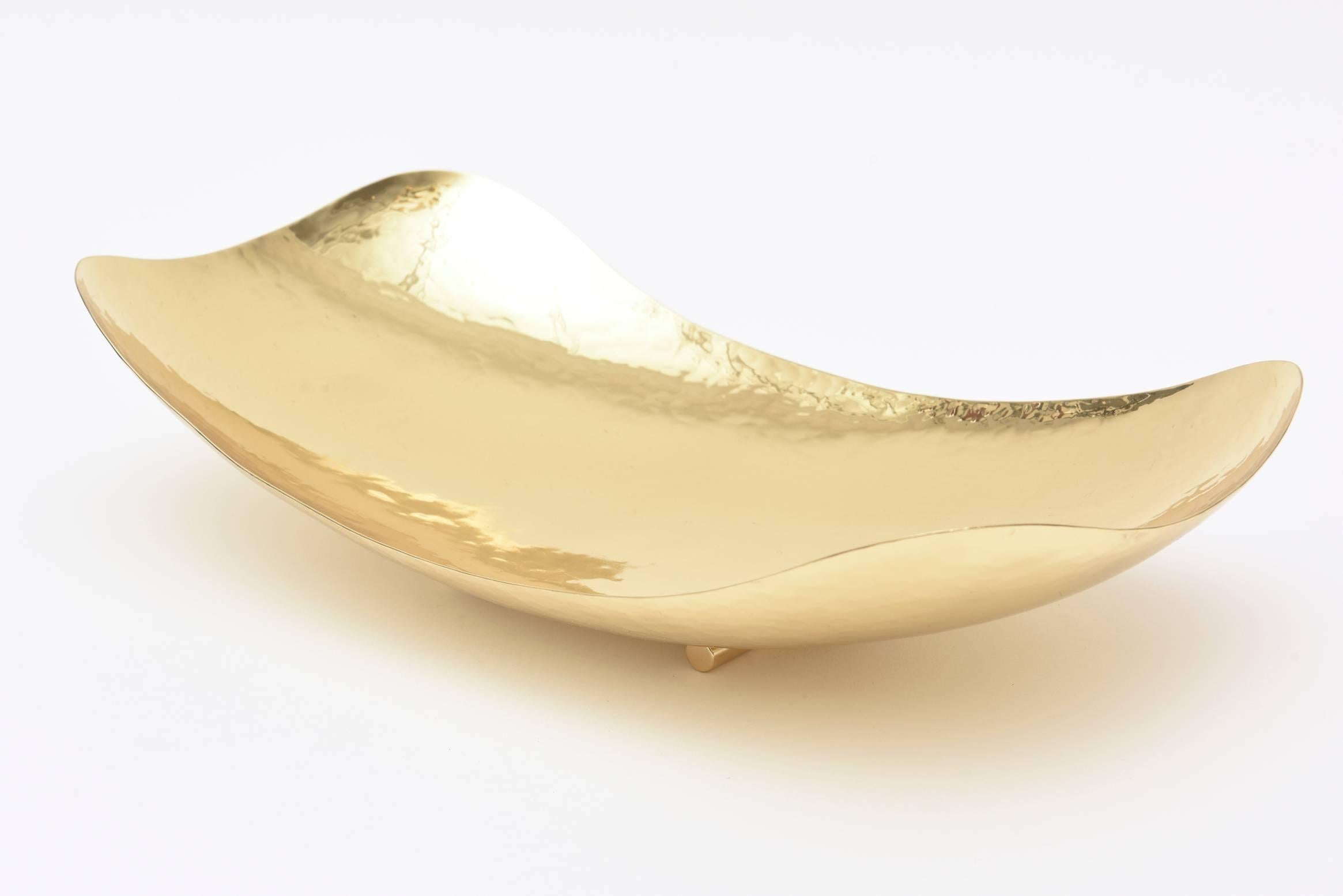 This gorgeous hand-hammered and newly polished brass bowl has been attributed to the work of Carl
Auböck. It is hallmarked Austria on the back. The shape is modern yet the time period is vintage midcentury. The sculptural shape is wonderful. The