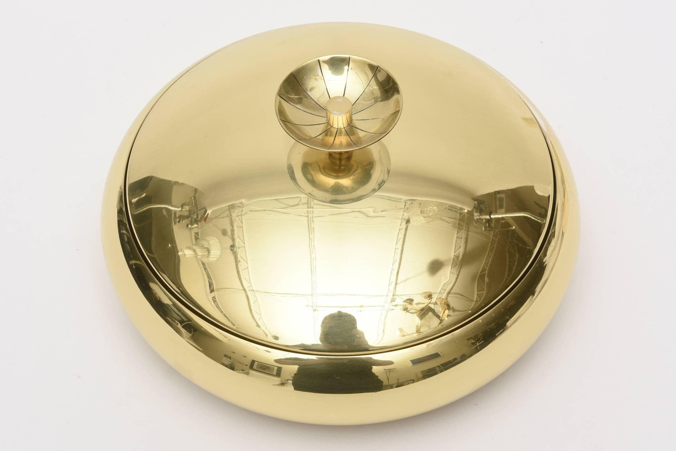 This hallmarked midcentury modern Tommi Parzinger polished and lacquered brass box or bowl is classic and timeless.
There is a glass insert from the time period for relish or pickles or olives. One can take that out and just use as a two-part chic