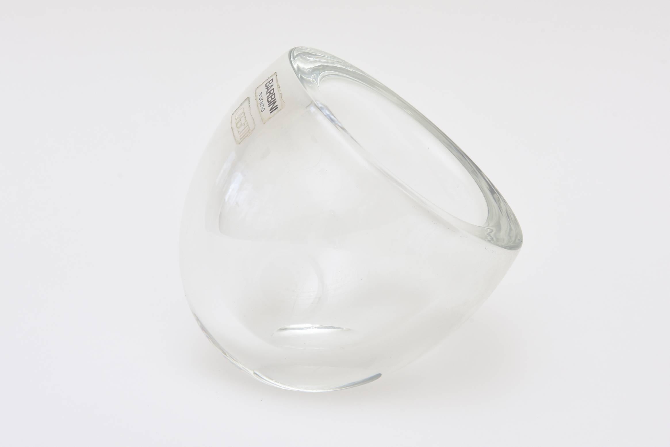 This iconic glass Italian Murano angled glass bowl or vessel has the two original plastic label that read Barbini Murano and Oggetti.
It is very sculptural and perfect for serving. It sits on an angle. It is great from all sides.
It can also house