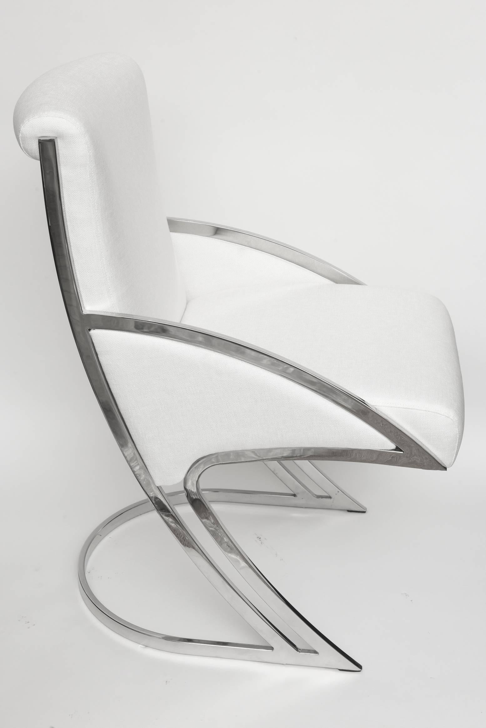 These sculptural vintage and comfortable dining chairs by Pierre Cardin are chrome-plated steel with new upholstery in white like linen fabric. They have been totally gutted and re-upholstered. There are four armless and two-arm. Measures: The width