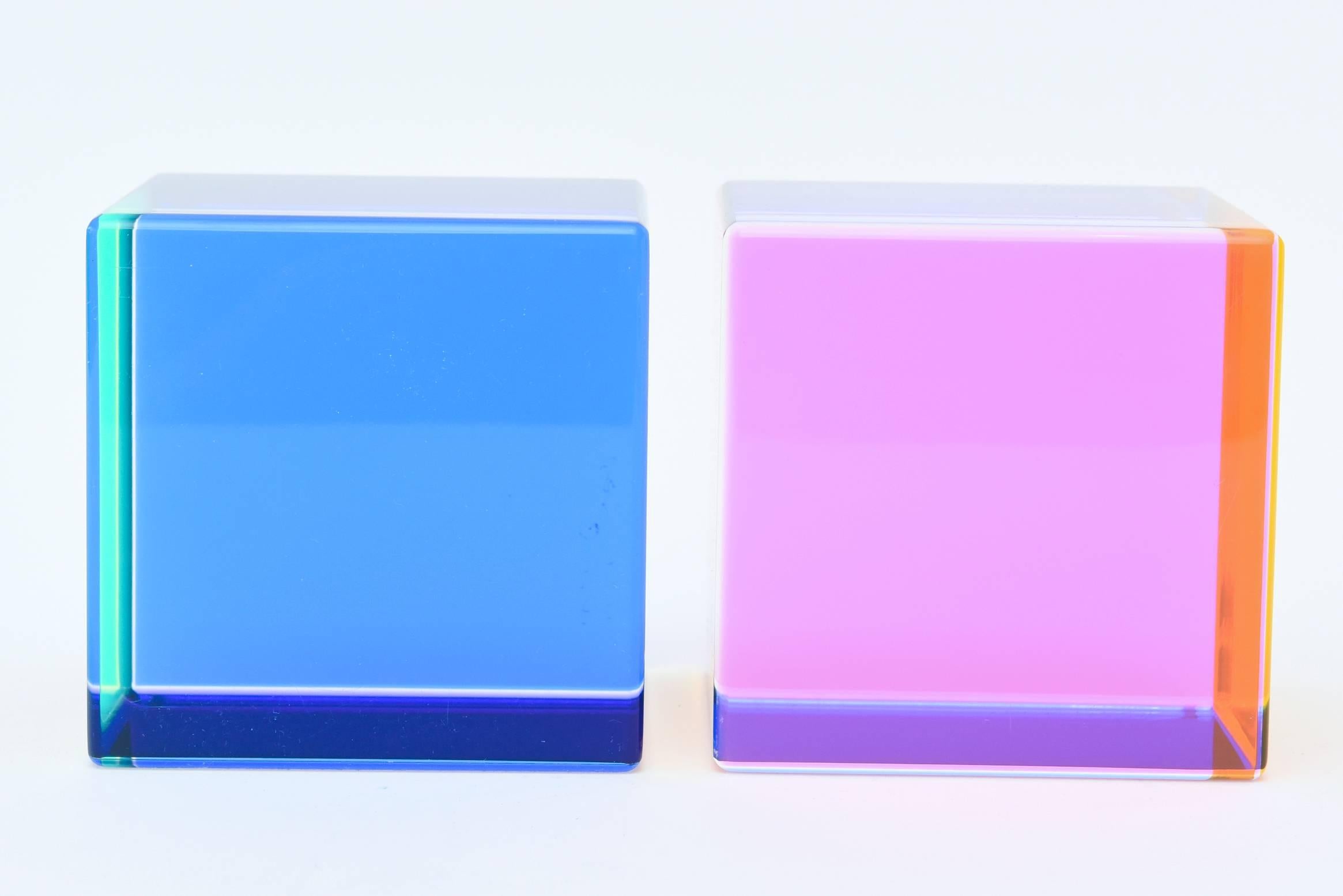 These fantastic and amazing colored laminated square Lucite large cube sculptures are signed by Vasa, 1993.
With each side and way you look at them and with the play of light entering in, they change color.
They are much more arresting in person