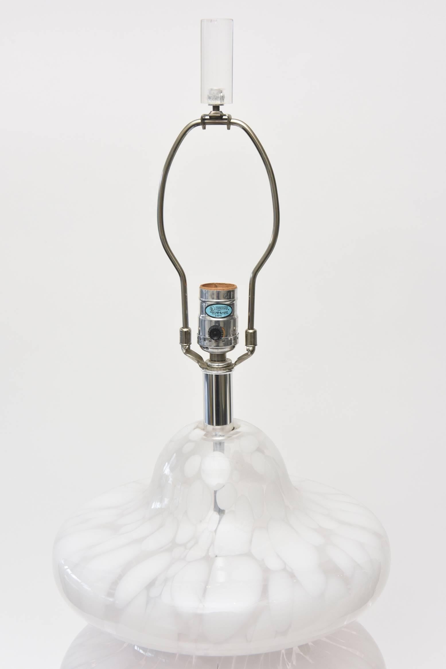 This beautiful Italian vintage Murano Carlo Nason for Mazzega four-tier pagoda style glass desk or table lamp sits on a lucite round base and has a an original lucite finial. The white swirls of glass sit admidst clear glass giving an abstract