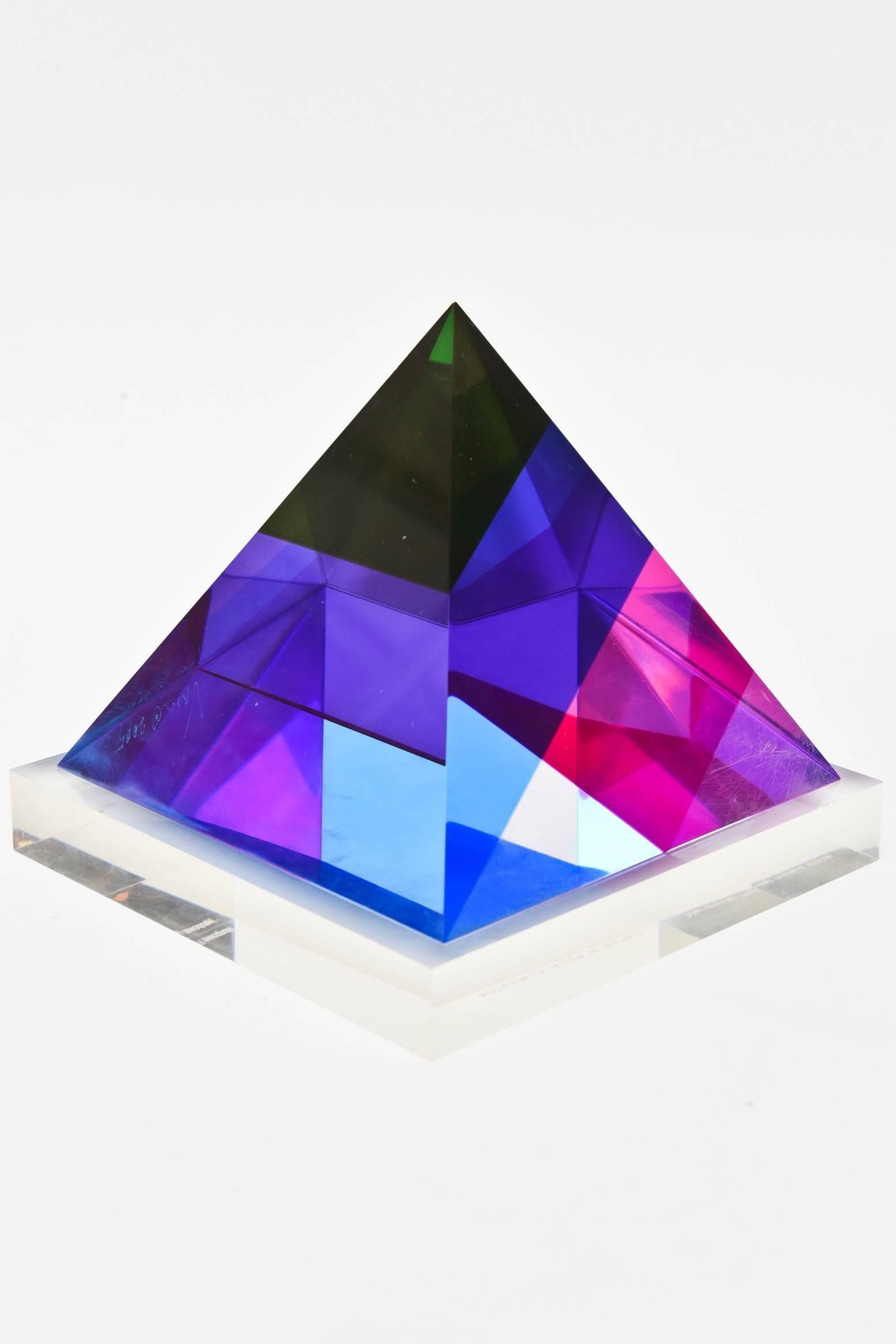 This gorgeous signed Vasa Mihich laminated one of a kind Lucite triangle sculpture is dated 2005. It is etched at the bottom as such.
Vasa has perfected and was the innovator of this type of Lucite that changes color and form with each angle and