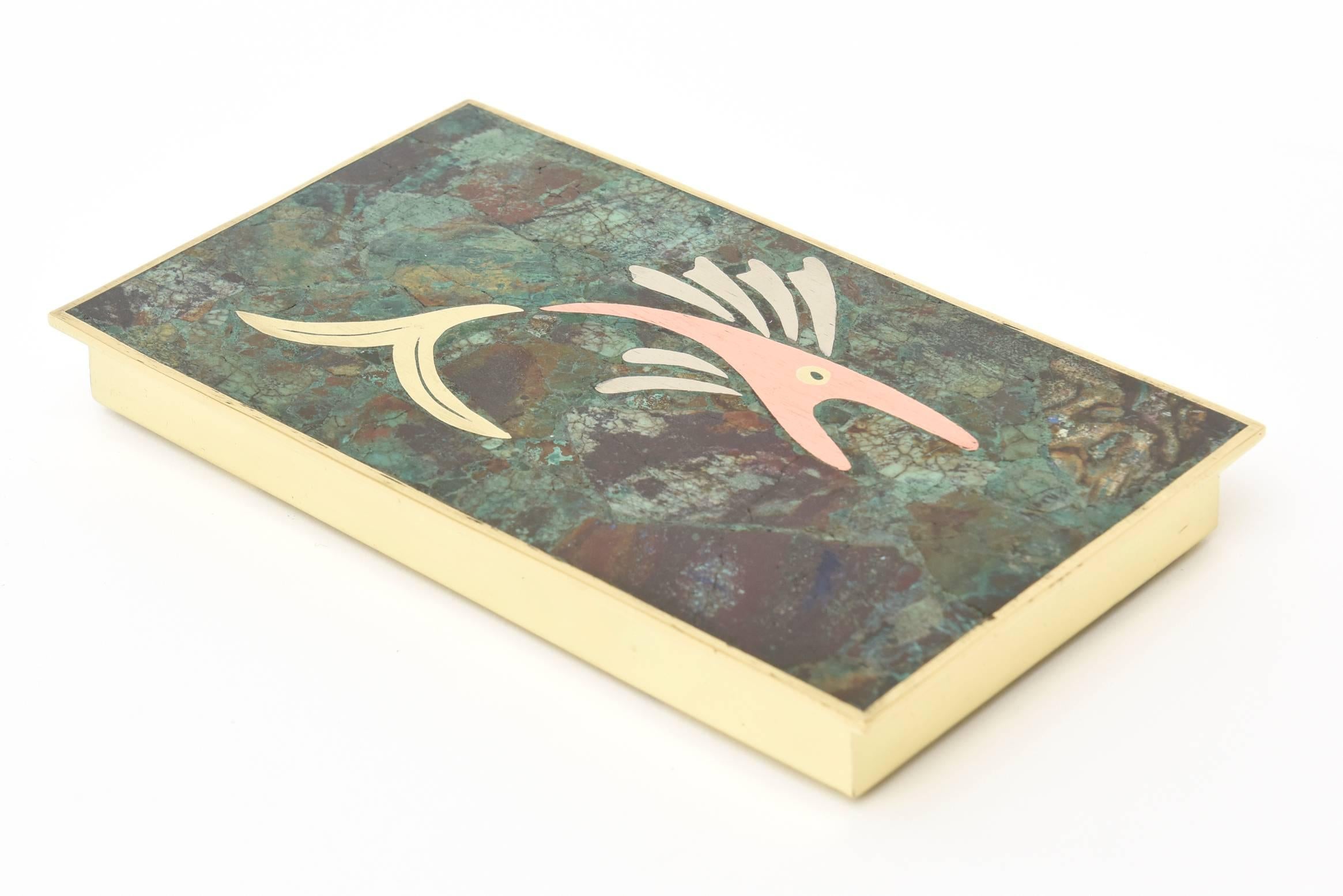 This lovely hallmarked Mexican Mid-Century Modern hinged box has mixed metals of brass, silver plate and copper along with sodalite, malachite and turquoise stone pieces. The fish motif in mixed metals on top of the box sit on the different stone