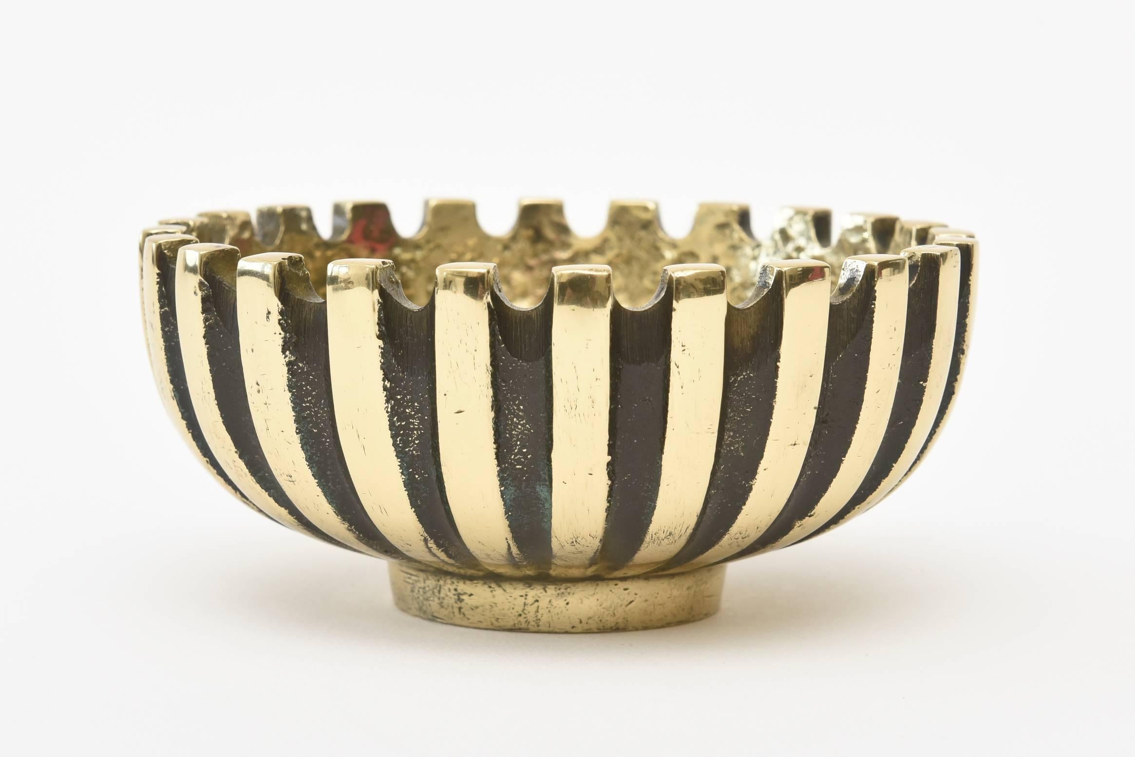 This heavy striking solid brass and blackened midcentury brass bowl has alternating lines of black against gold. This has been attributed to the design of Maurice Ascalon for Pal- Bell Co. It is marked on the bottom Made in Israel. The interior is