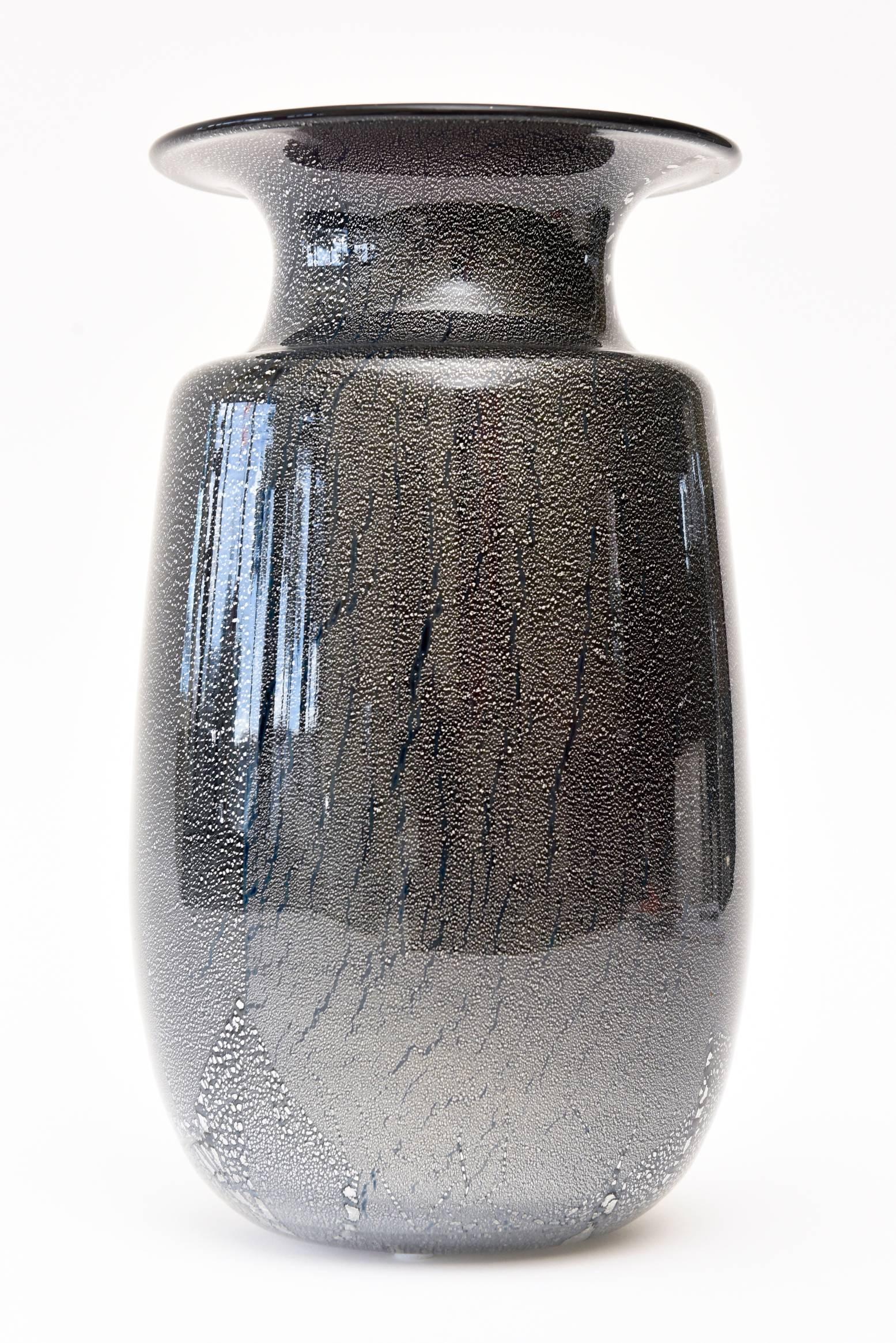 This stunning Italian Murano Seguso vase or vessel is black amethyst glass infused with an abstract and random design of silver foil infusions and droplets.
It has a very Japanese type landscape abstraction to the layered cased glass. It is infused