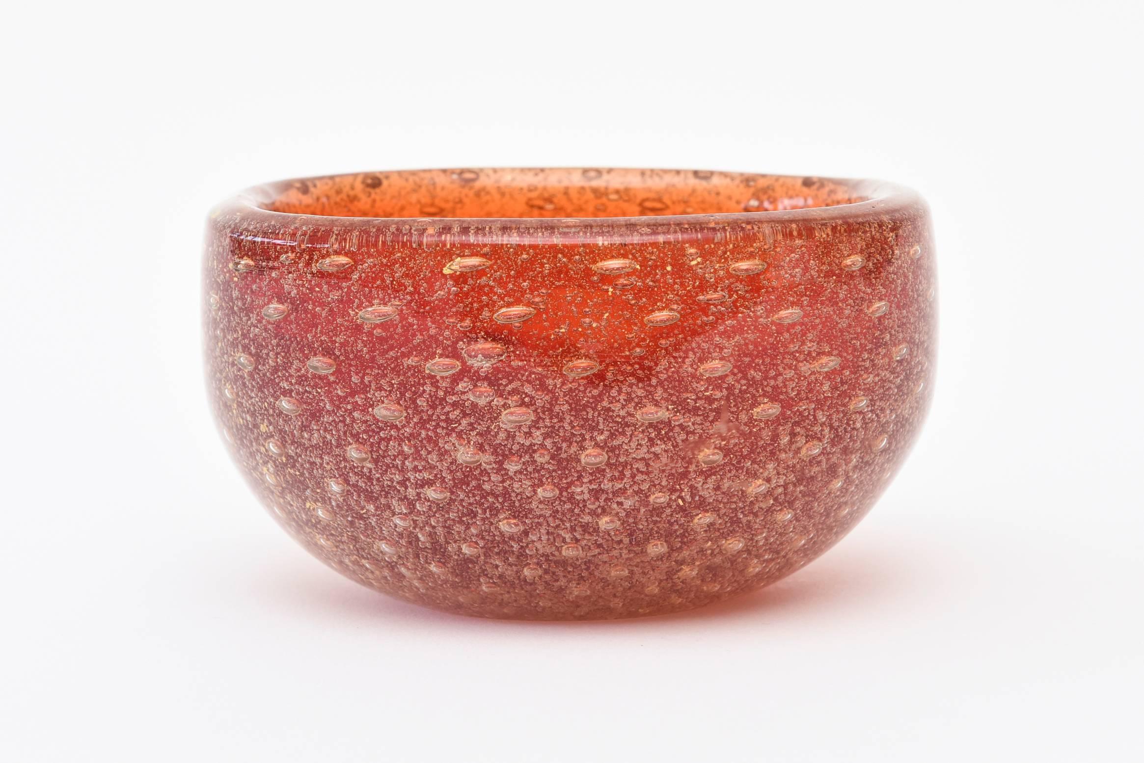 This small luscious vintage Mid-Century Modern Italian Murano Venini square red bowl has abundant bullecante with gold aventurine throughout and is acid etched on the bottom; Venini Made in Italy. The corners are rounded. The red is more of a paler