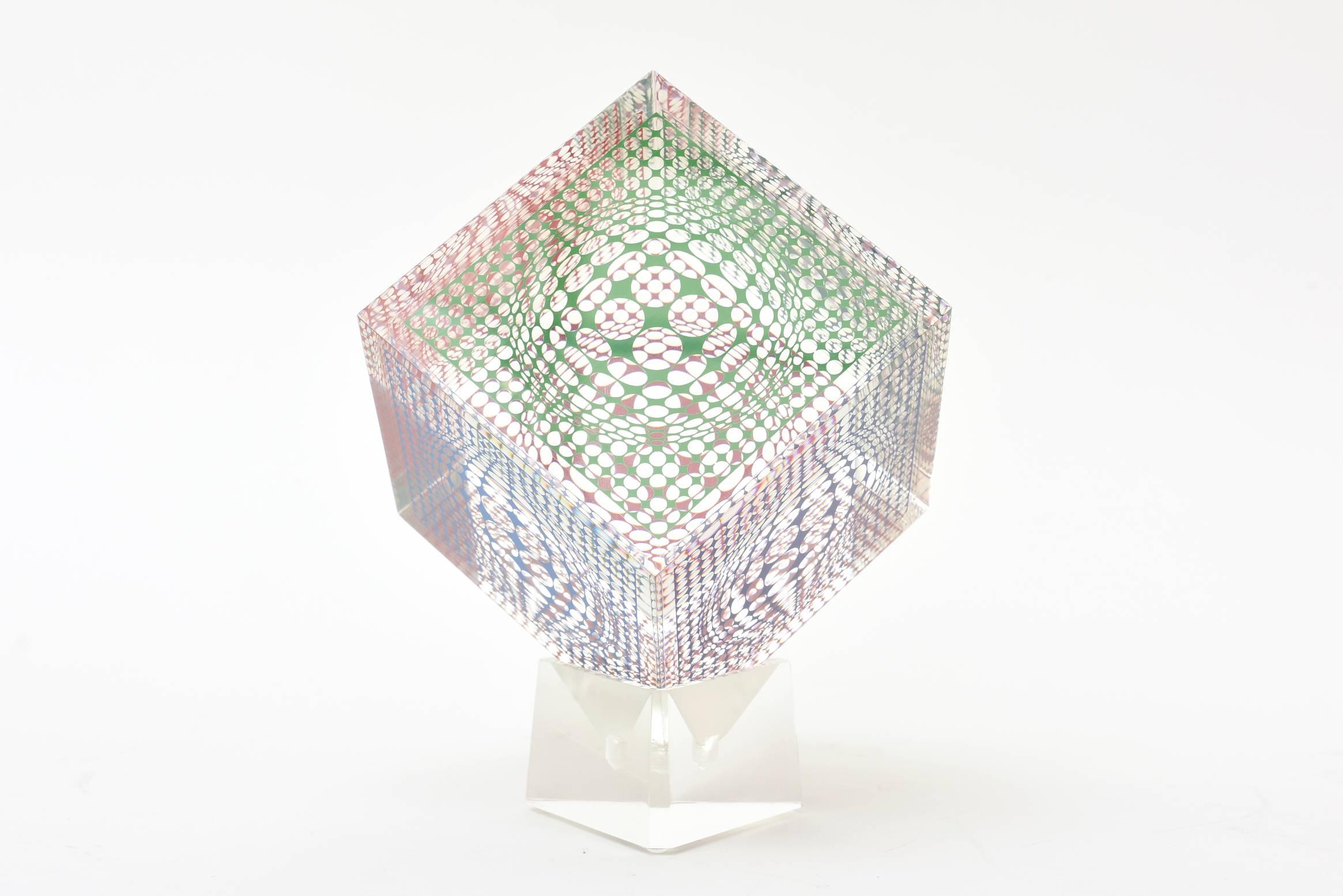 This wonderful angled Victor Vasarely op art Lucite sculpture is different color patterns and graphics on all four sides. It creates an optical movement and illusion. One can change each side in the Lucite stand. This one is great!
Vasarely was the