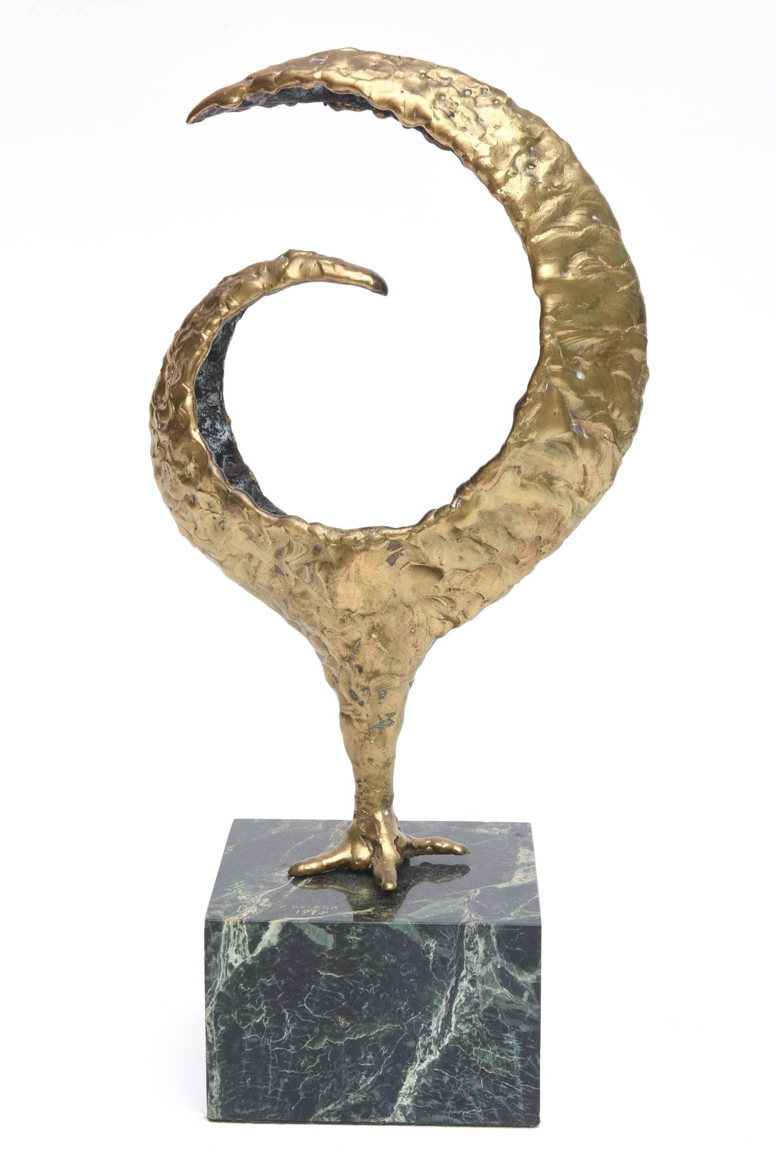This heavy molten bronze question mark, bird or chicken sculpture has the traccia feet that is reminiscent on the coveted Meret Oppeneheim table. It sits in the original variegated green and black marble base with a bronze pole. The sculpture is