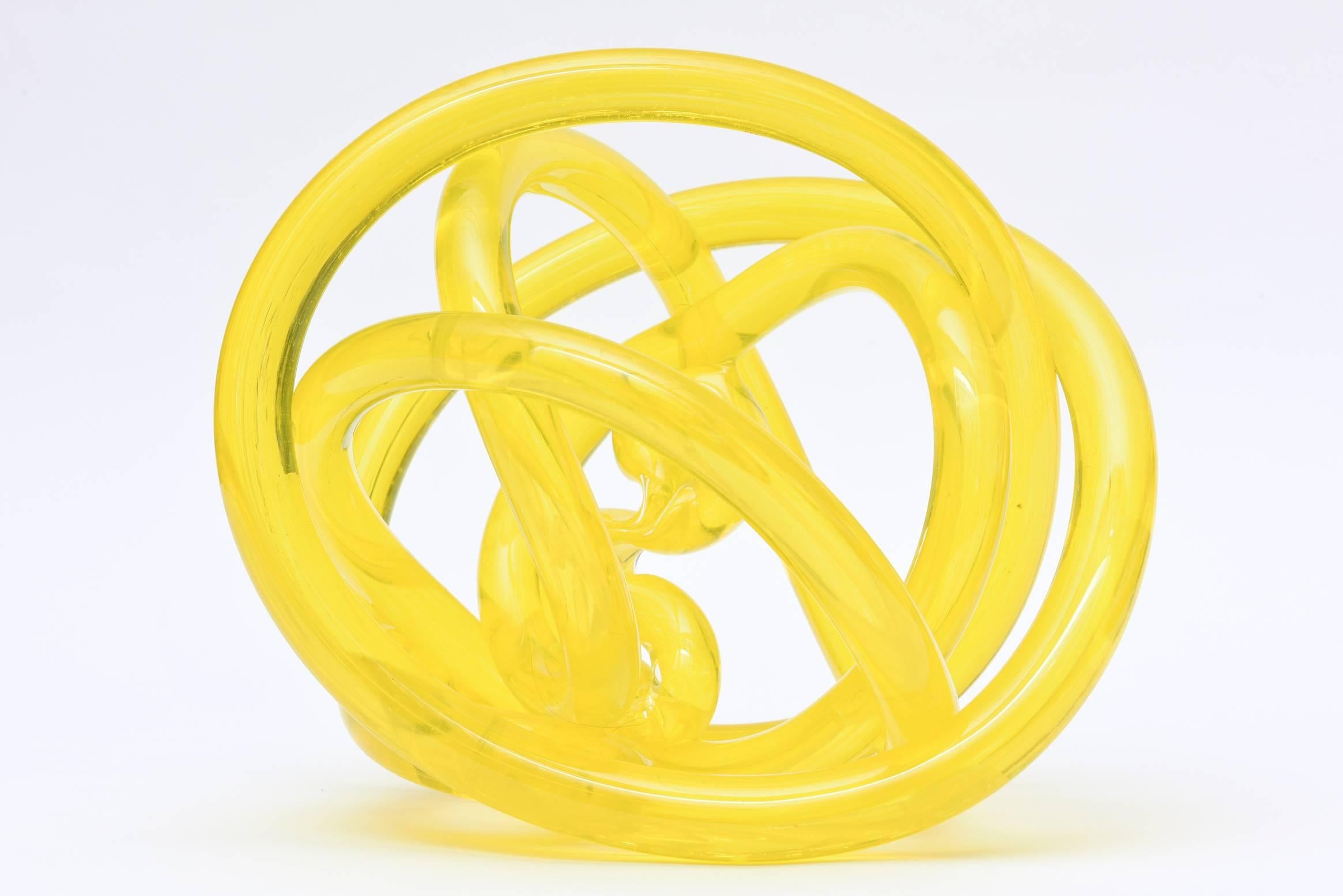 This Italian Murano lemon cello twisted glass knot sculpture is abstract. It is made by Cenedese and looks like it has an abstract figure/body in the interior. The twisted tube like glass forms go round and round.
This is a happy and more unusual