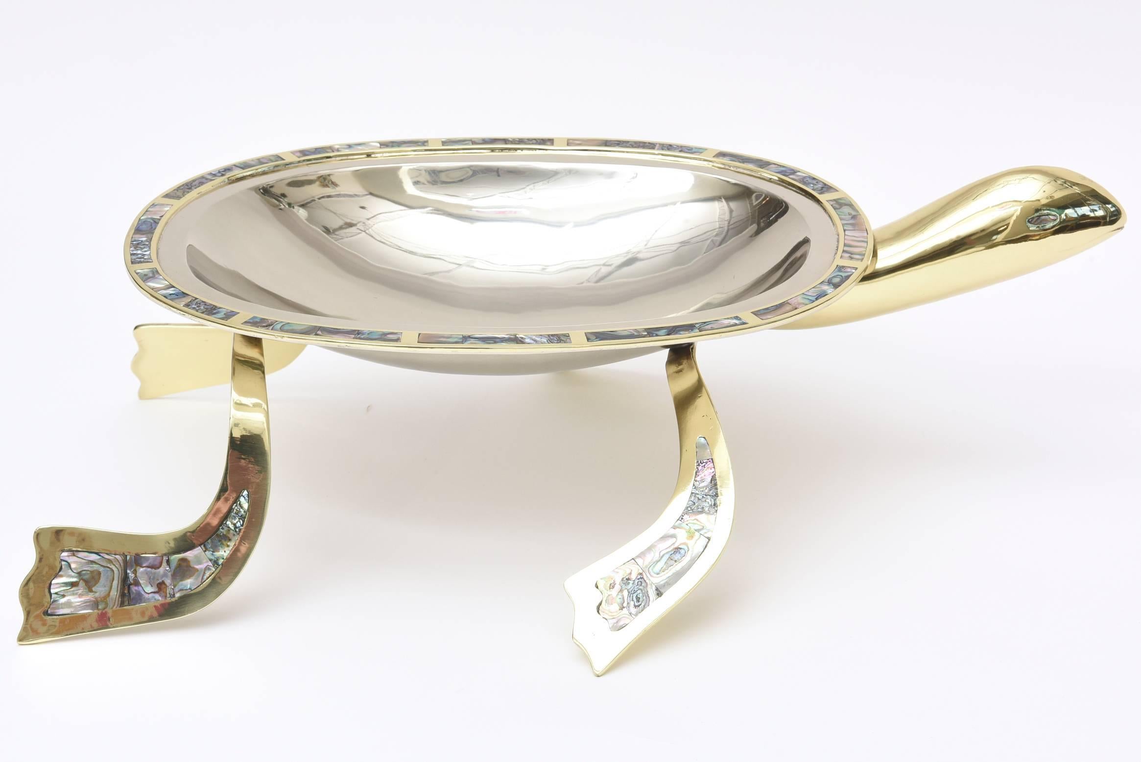 The combination of abalone, brass and silver plate make this dramatic and fun monumental turtle serving piece or centerpiece bowl a great conversation piece. It has all been professionally polished. The abalone eyes and legs and perimeter make this