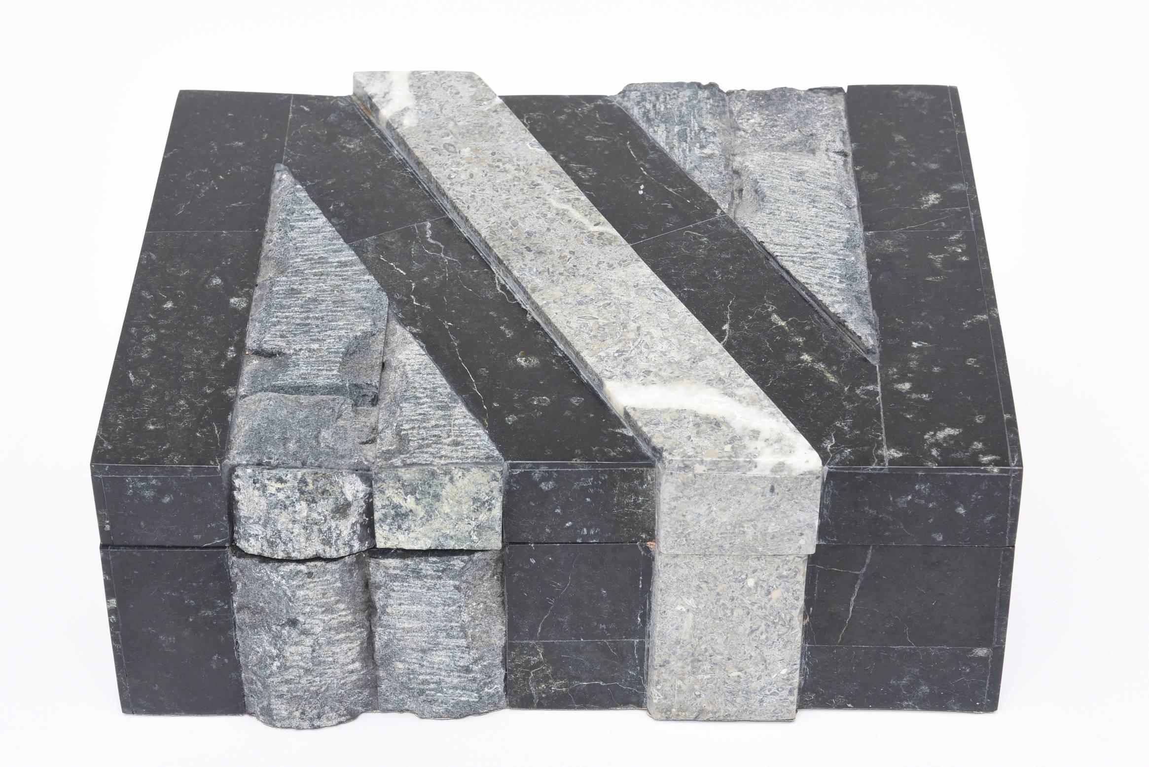 This handsome box comprising of both the yin and the yang of polished and rough stone is quite sculptural.
It has dimension, texture, and a great look. The stone protrudes and is angled and creates lines.
Greys and black play well together with