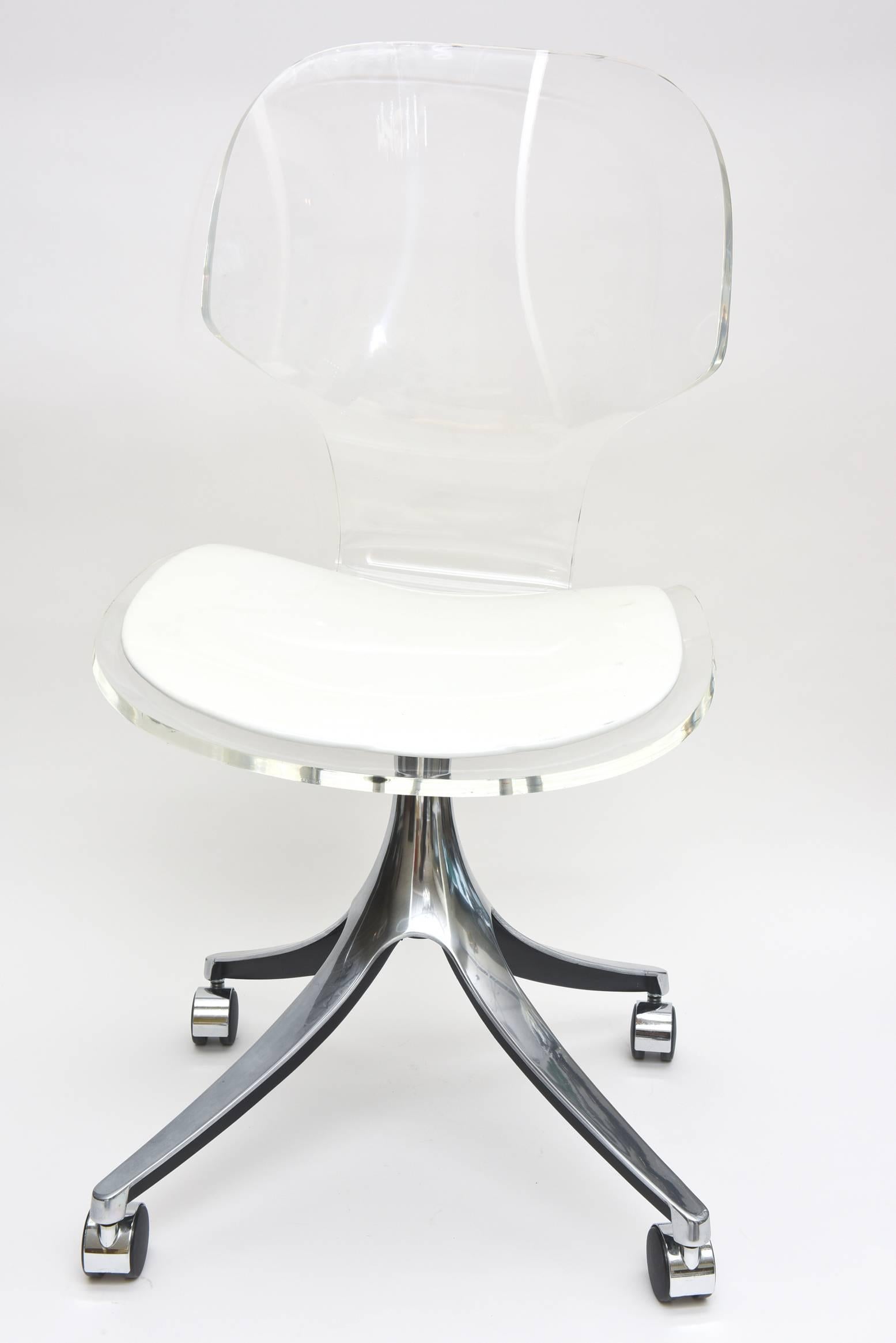 This very comfortable and vintage chic polished Lucite, chrome and original white vinyl desk/vanity chair has it's original wheels.
It moves easily.
The white vinyl seat is original. One may want to change that.