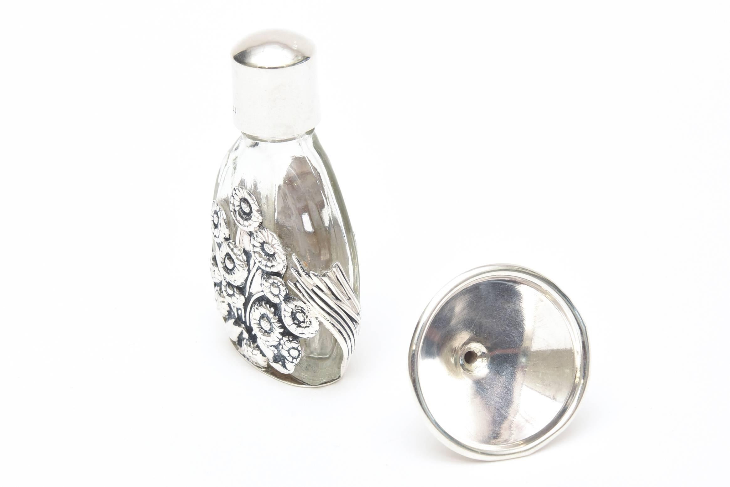 This lovely Art Deco sterling silver raised overlay of a floral design over glass houses your favourite perfume for travel or in a glamorous evening bag.
This has its original sterling silver funnel to pour the perfume into its little luxe bottle.