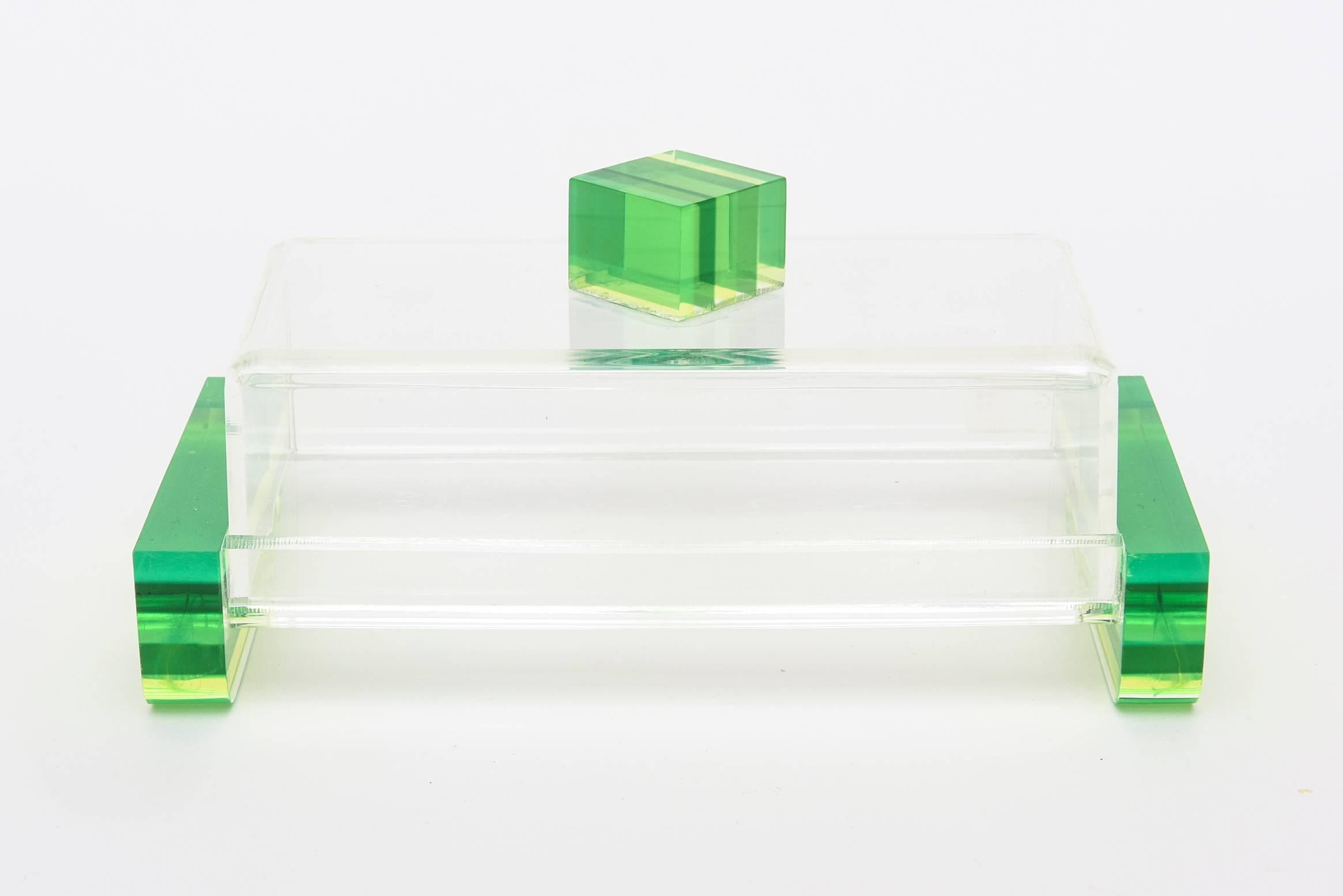 Luscious colors of chartreuse meet green in this arresting and fun 2 part box. It is in the style and attribution of Charles Hollis Jones. The top square when looked at different angles has black lines in between the chartreuse. The clear Lucite of