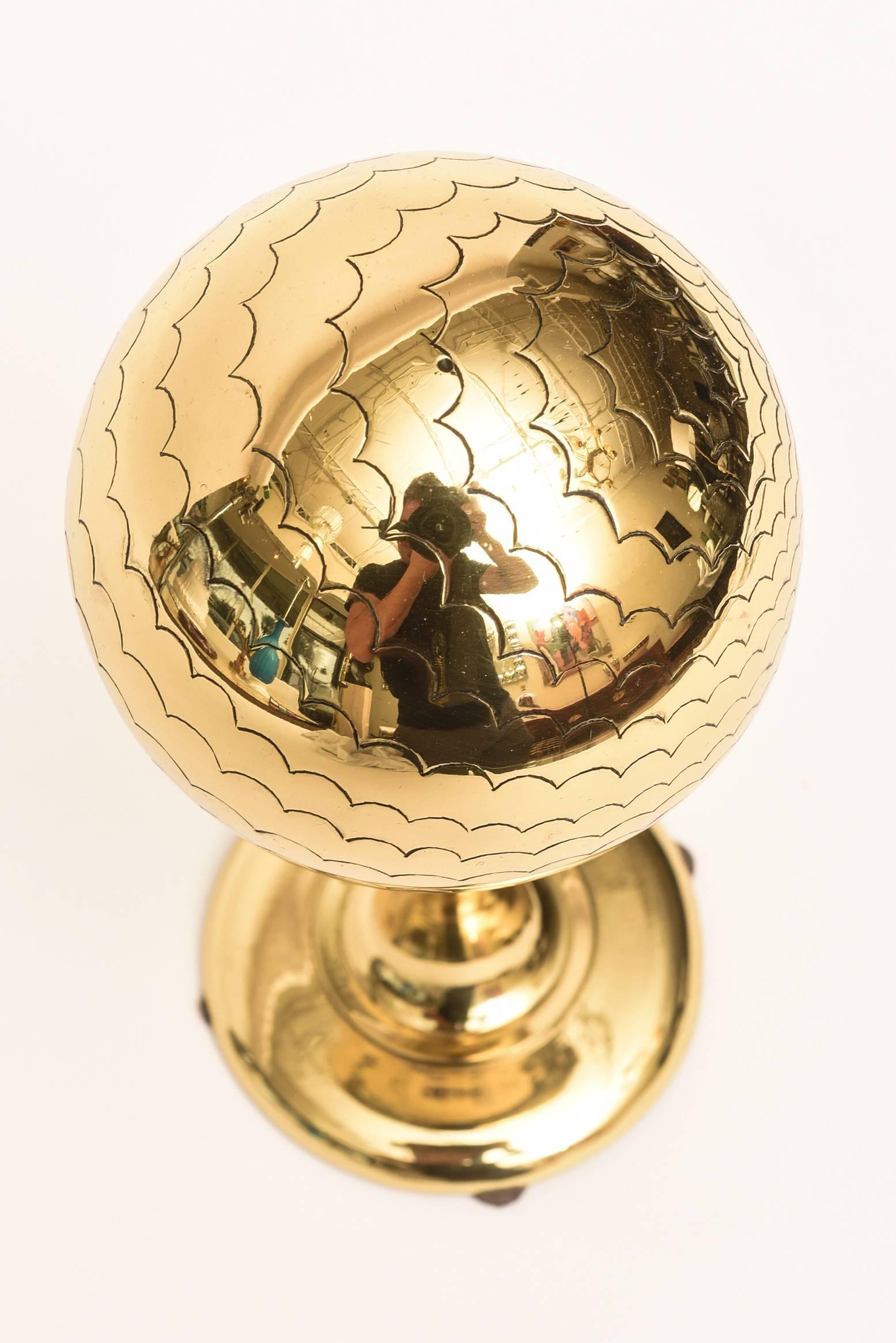 This Mid-Century Modern desk accessory or cocktail table sculpture is a solid brass polished globe like object with scalloped designs on the top. This is very well made from the time period and has good weight to it. It is from then 1950s.
  