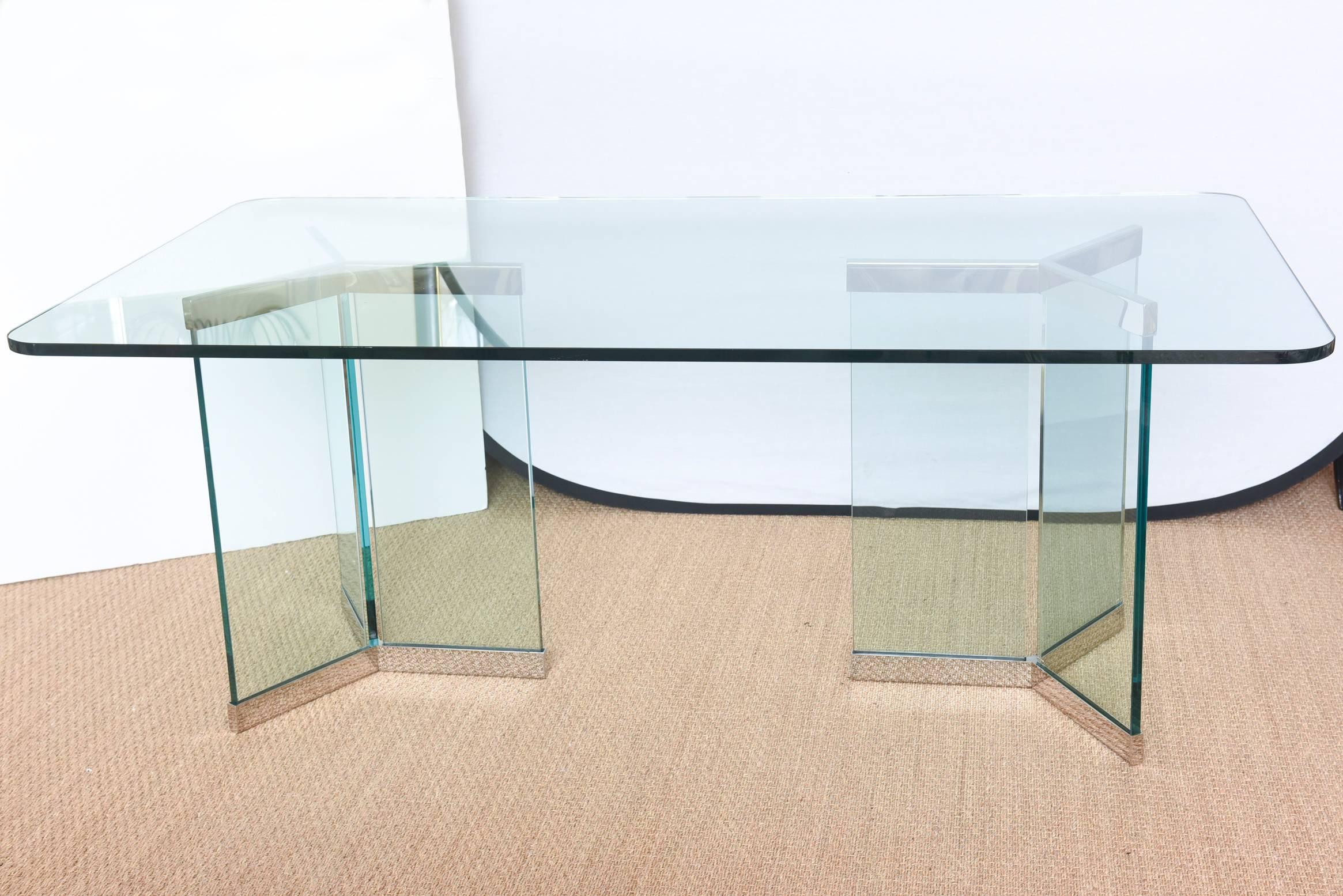 Stainless steel mixes with triangular columns of glass as the bases for this classic and timeless Leon Rosen for Pace dining table or desk. It is modern yet classic yet sculptural. Original glass top that has green edge and radius corners. The glass