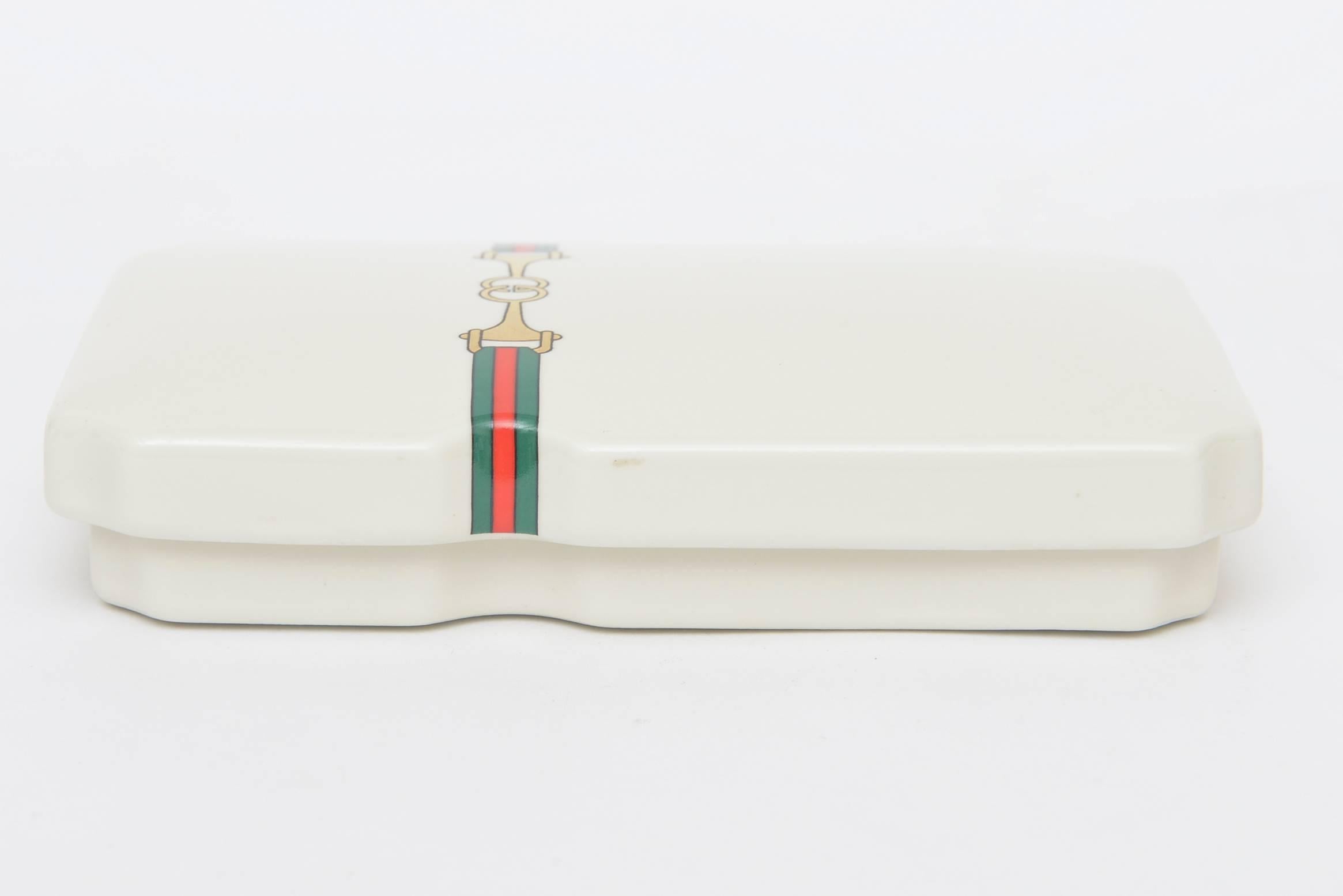 This vintage Gucci two-part lidded porcelain incense box is a great gift.
Just a few of the small pieces of incense remain from the original owner. They were red and green. The incense porcelain container is inside and bordered with gold