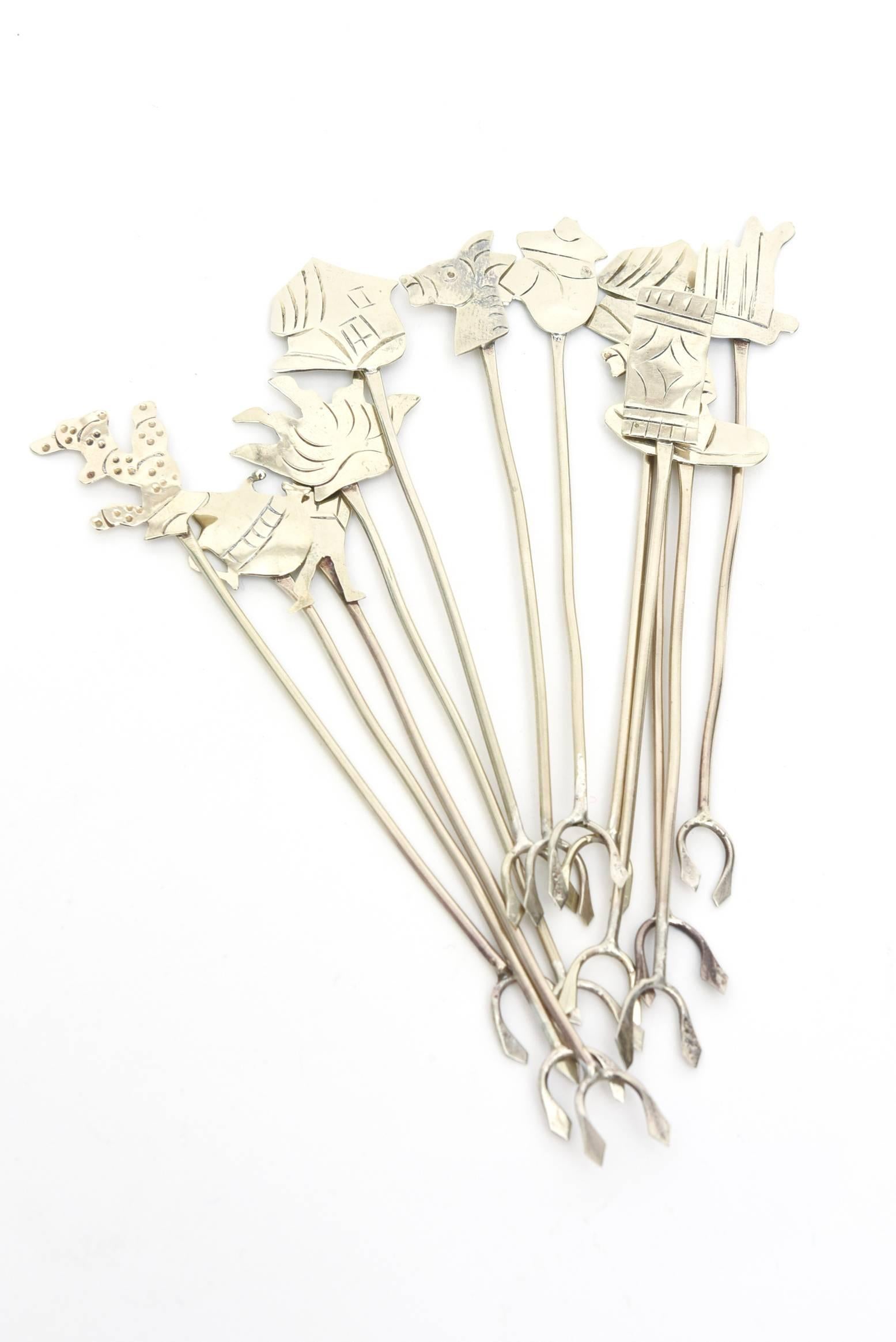 These delightful silver-plate Taxco olive picks or shrimp forks/cocktail have 12 different depictions of symbolic Mexican forms and animals. Some examples are a horse, a sombrero, etc. Their end is in a shape of a pitchfork. Marked Taxco.
They have