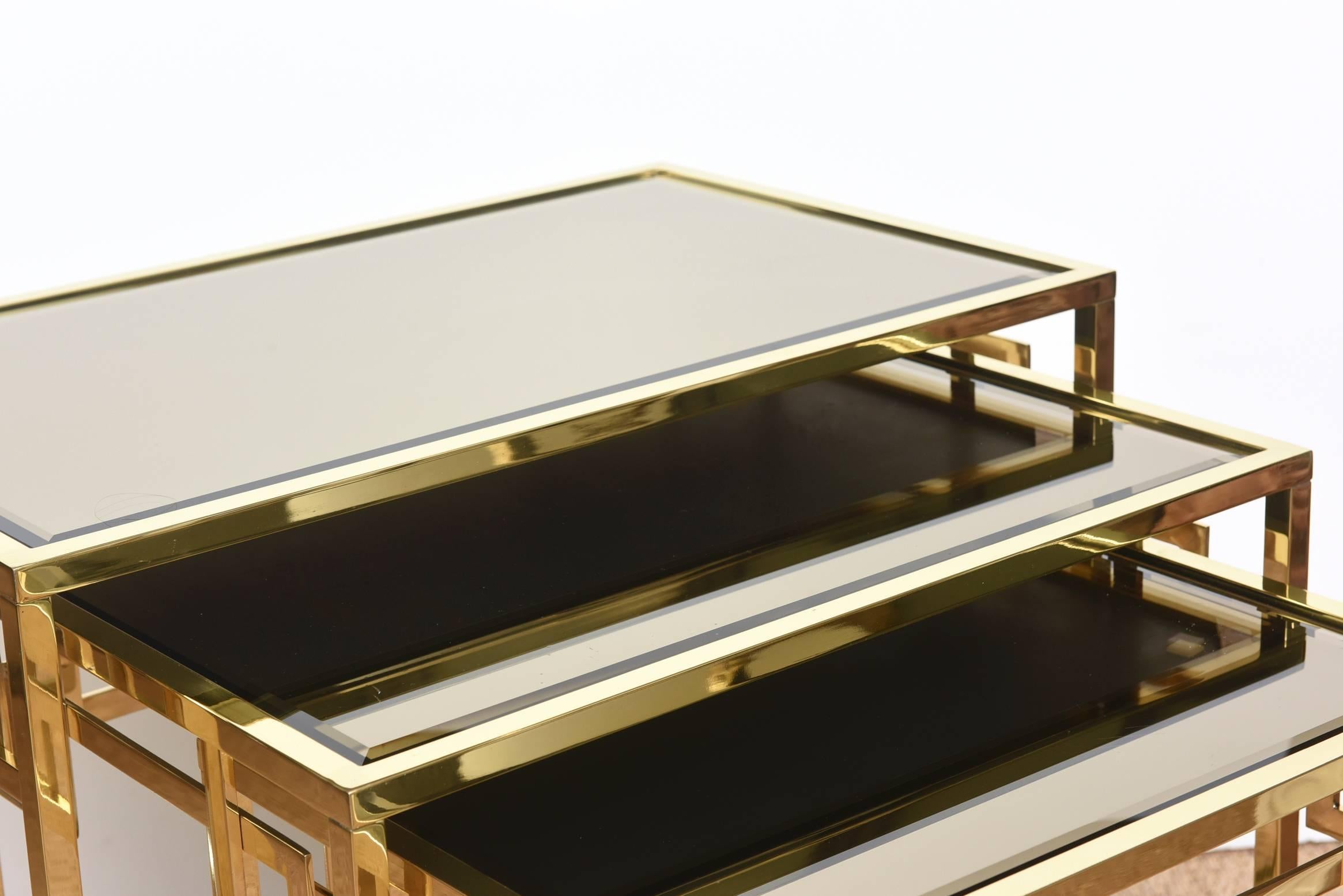 Dieser Satz von 3 italienischen Vintage-Schlüssel-Nesting-Tische sind poliertem Messing mit original verspiegelten Bronze Glasplatten. Sie wurden in Italien hergestellt. Das Design des griechischen Schlüssels ist immer zeitlos und klassisch. Sie