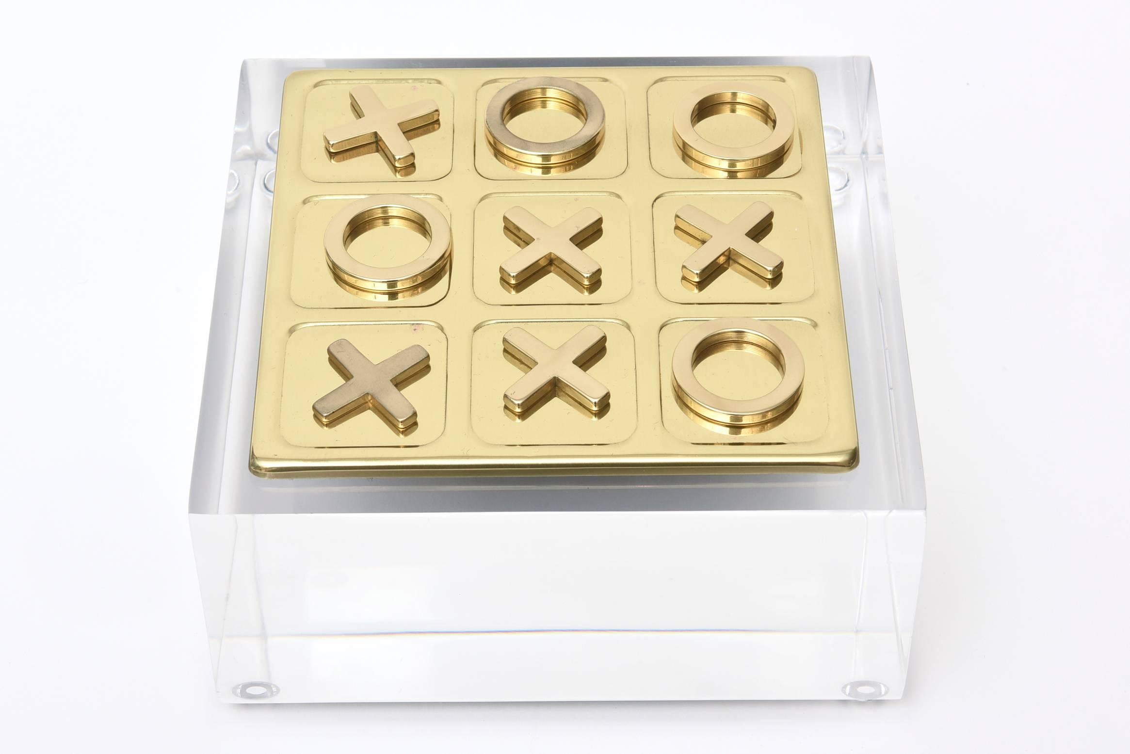 This is a small tabletop vintage game of tic tac toe of professionally polished brass resting on a thick Lucite base.
There is one extra player.
There is the board and ten players with the Lucite thick base.
The lucite base is not attached and is