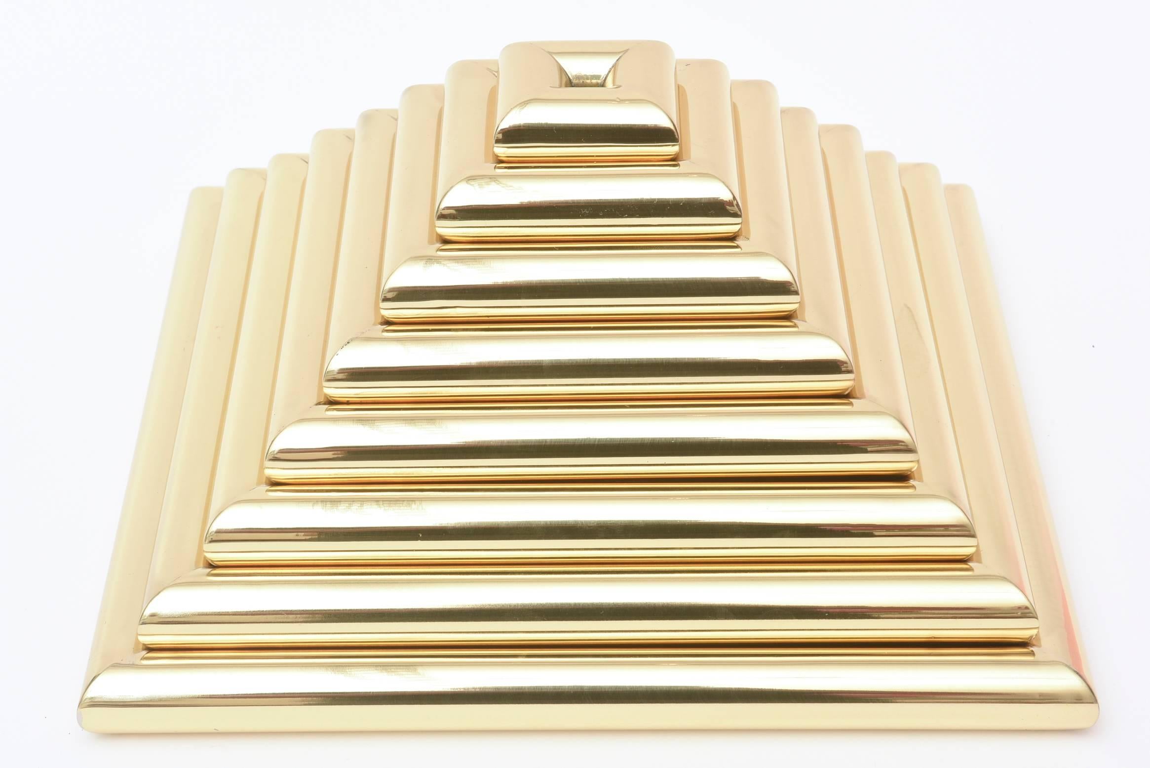 This great weighted eight-piece Italian vintage pyramid brass sculpture is the work of Romeo Rega from the 1970s. There are eight polished brass trays that are all removable and can be used for serving. They all come apart. It is a great sculptural