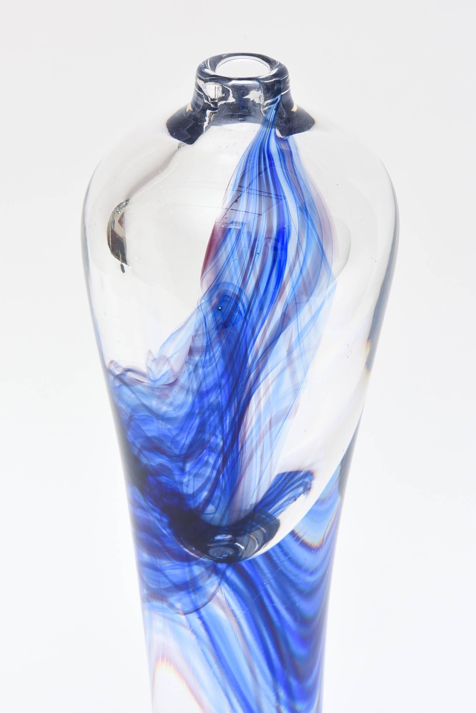 This substantial and very heavy signed and numbered Kosta Boda sculpture has the brilliant hues of Yves Klein blues and some swirls of purple.
It has a sticker of Kosta crystal and signed on the bottom as Kosta G. Warhunik 81-481. It is only 7