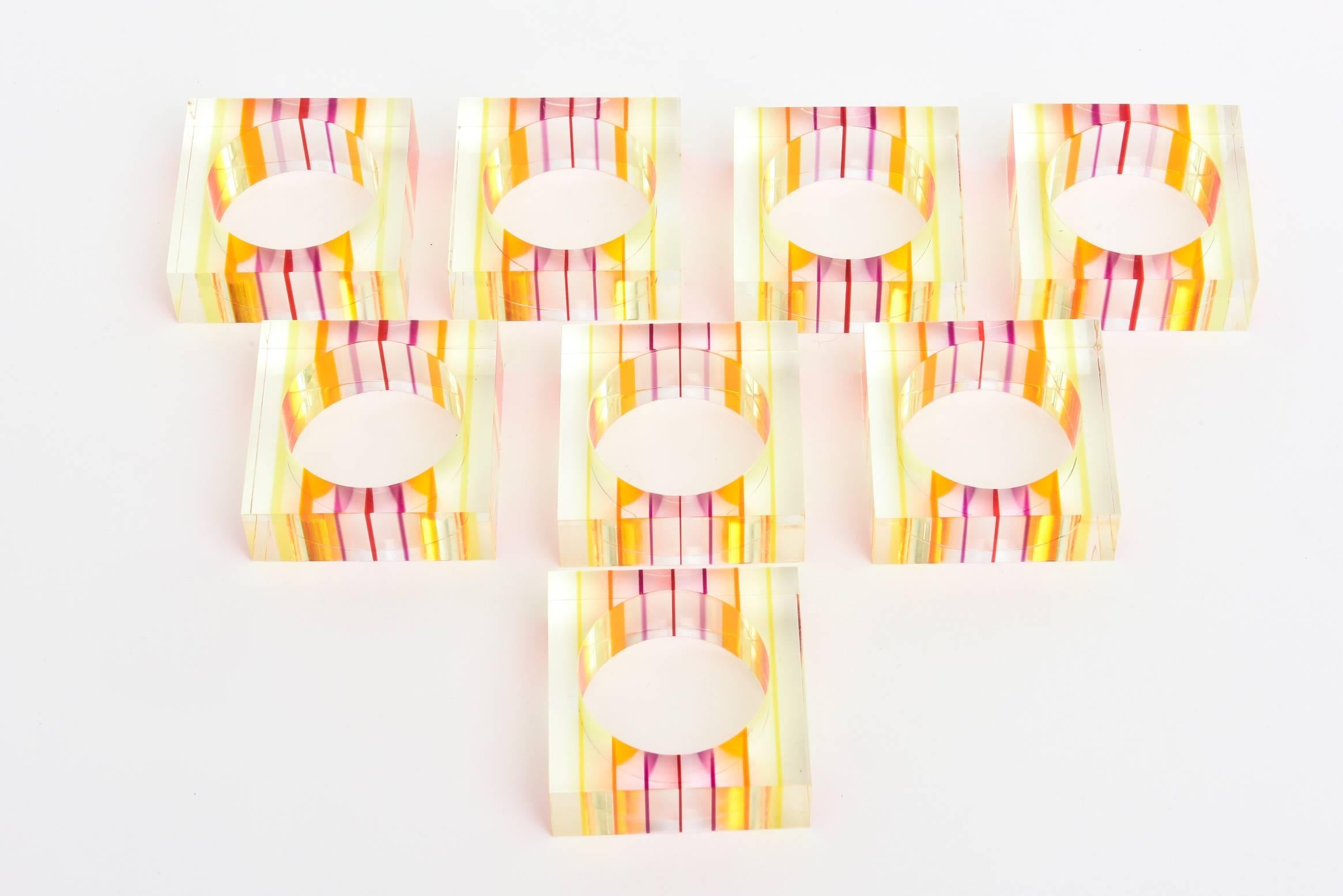 The attribution is Charles Hollis Jones striated napkin rings is shades of the summer and fun, oranges, yellows, pinks, purples, reds all mix in the square and create an optical illusion in these Lucite napkin rings.
They are happy, optical and a