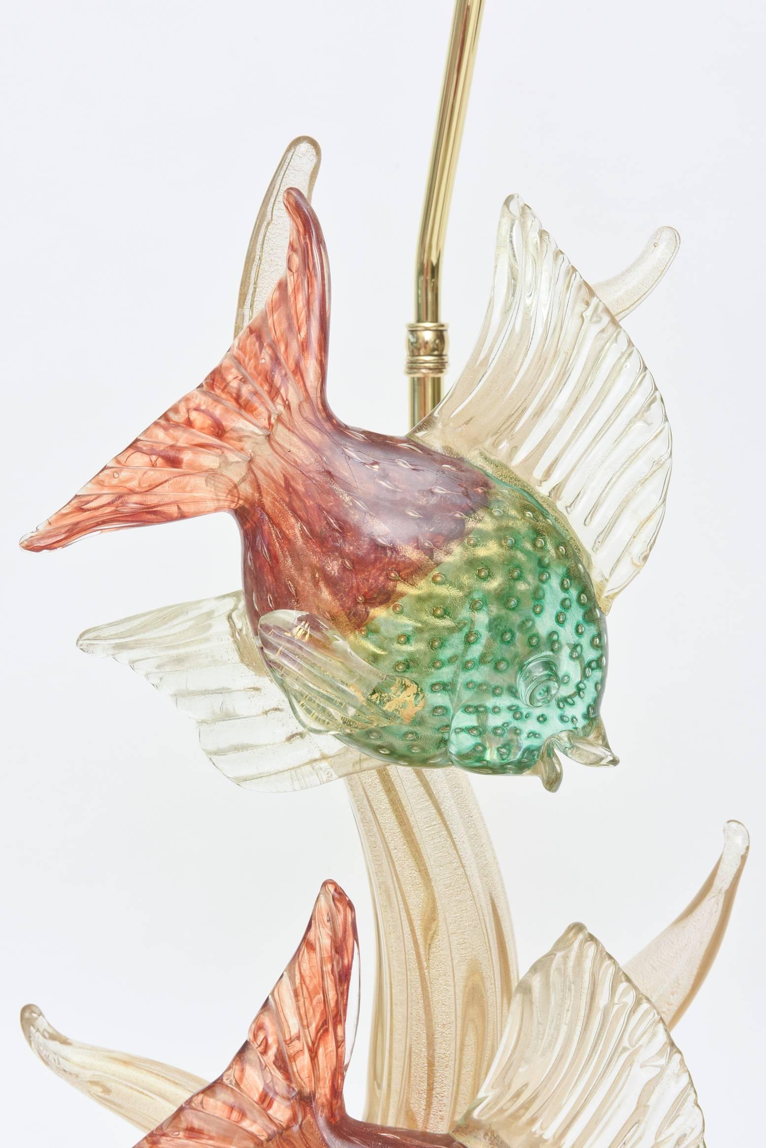 These very early, rare and gorgeous Italian Murano lamps by Barovier e Toso have tons of gold aventurine interspersed with the bullecante. (bubbles) The fish are beautiful in their rich elegant colors of sea green and cranberry red with gold and