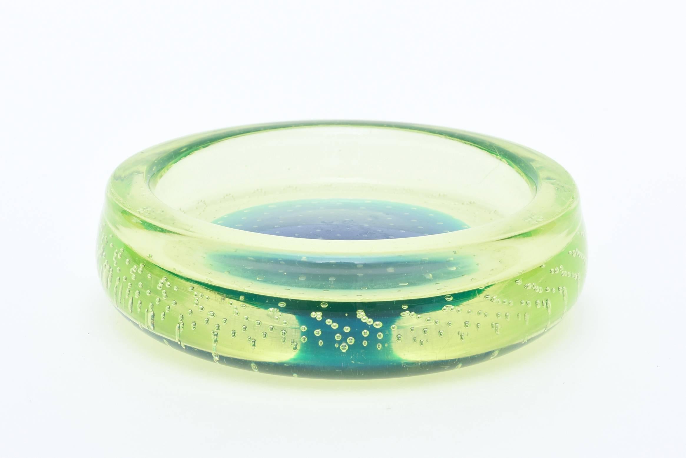 The luscious colors of chartreuse green meet up with the center of sapphire blue amongst plentiful bubbles called bullecante in this arresting Italian Murano glass bowl.
The top is polished with polished underlip and it is sculptural.