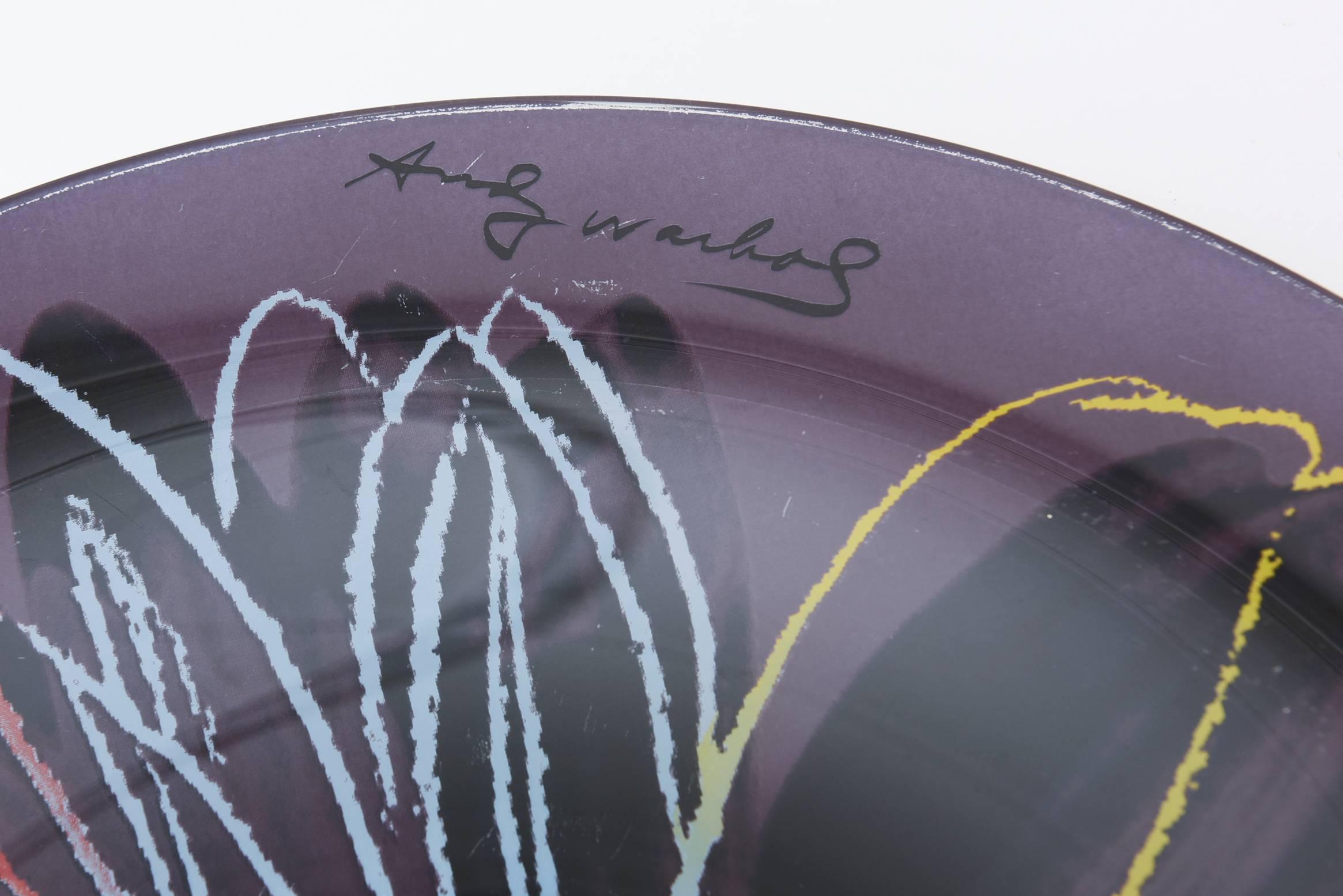 This wonderful painted glass plate depicts a work by Andy Warhol, produced by the Rosenthal Studio Line. The beautiful flower is set amongst aubergine/purple background with red, blue and yellow.
Great for serving or just as is.