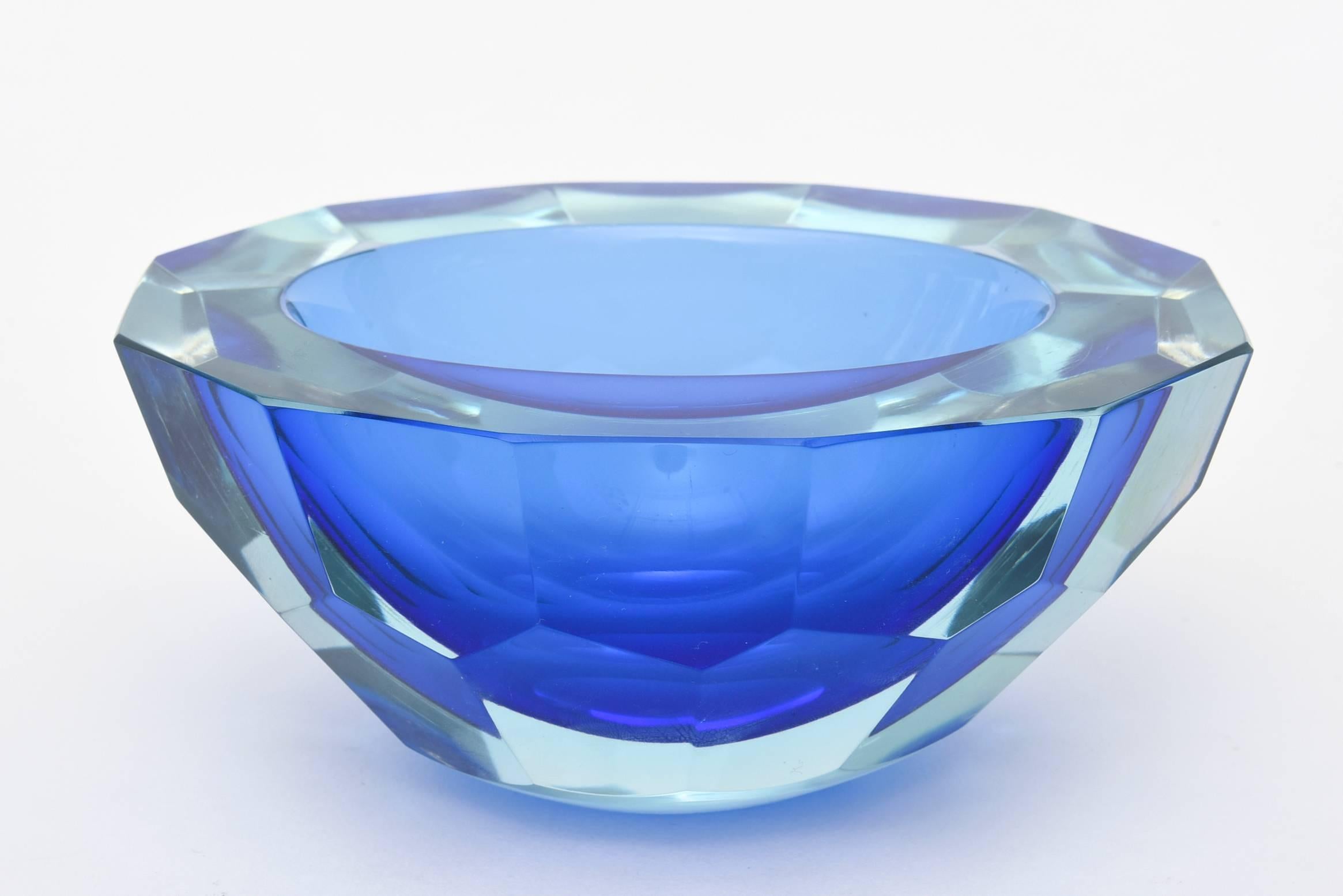 This stunning and heavy Italian Murano two-toned Sommerso glass geode bowl is like chilsed piece of sculpture in glass. It has the flat cut polished top and faceted exterior.
The play of the blues are luscious and the honeycomb pattern is