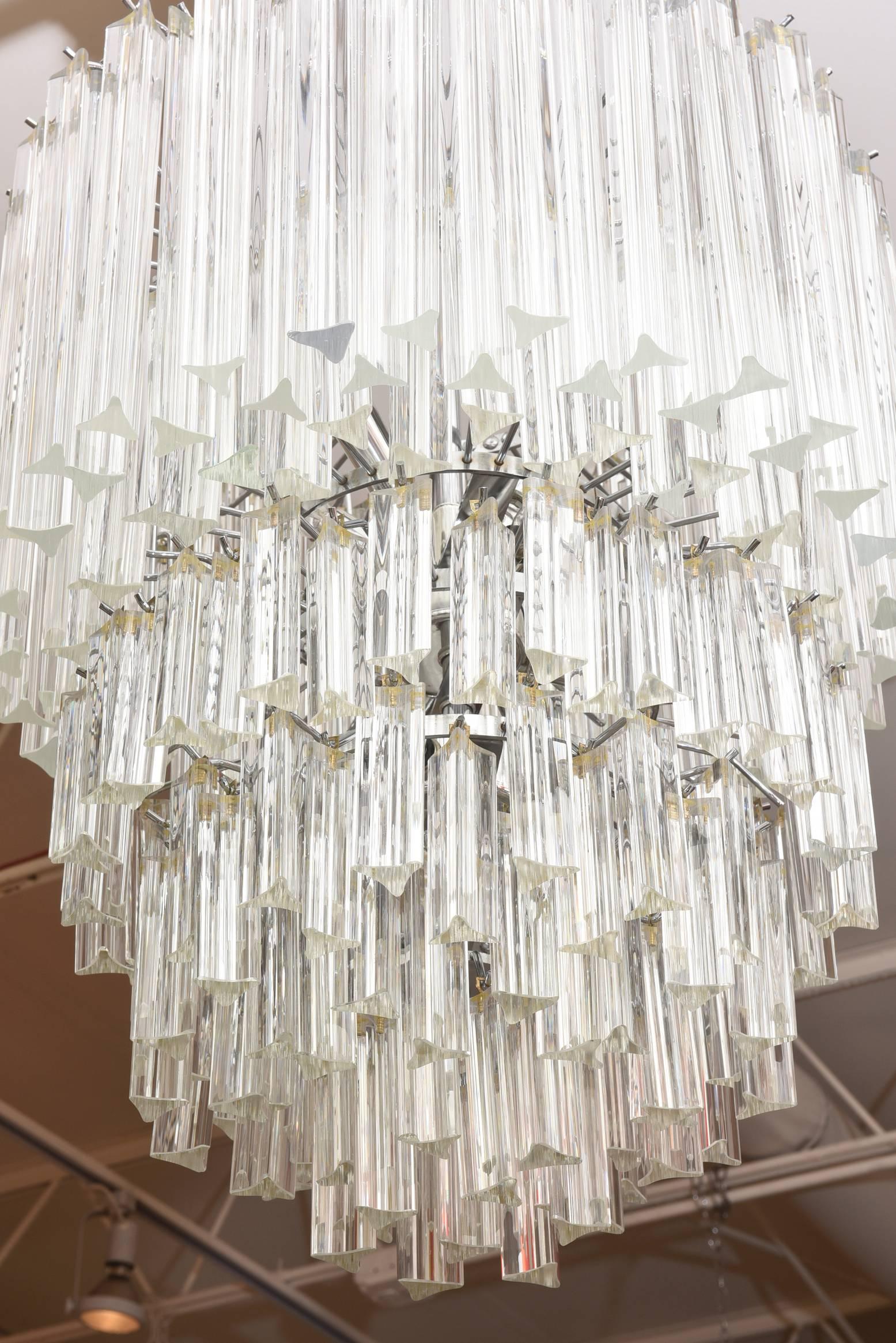 In this vintage Murano Venini chandelier are five tiers of hanging prism glass pendants that make up this chandelier. It is Italian and the five level cage has been nickeled silver. The height listed below does not include the chain or canopy. One