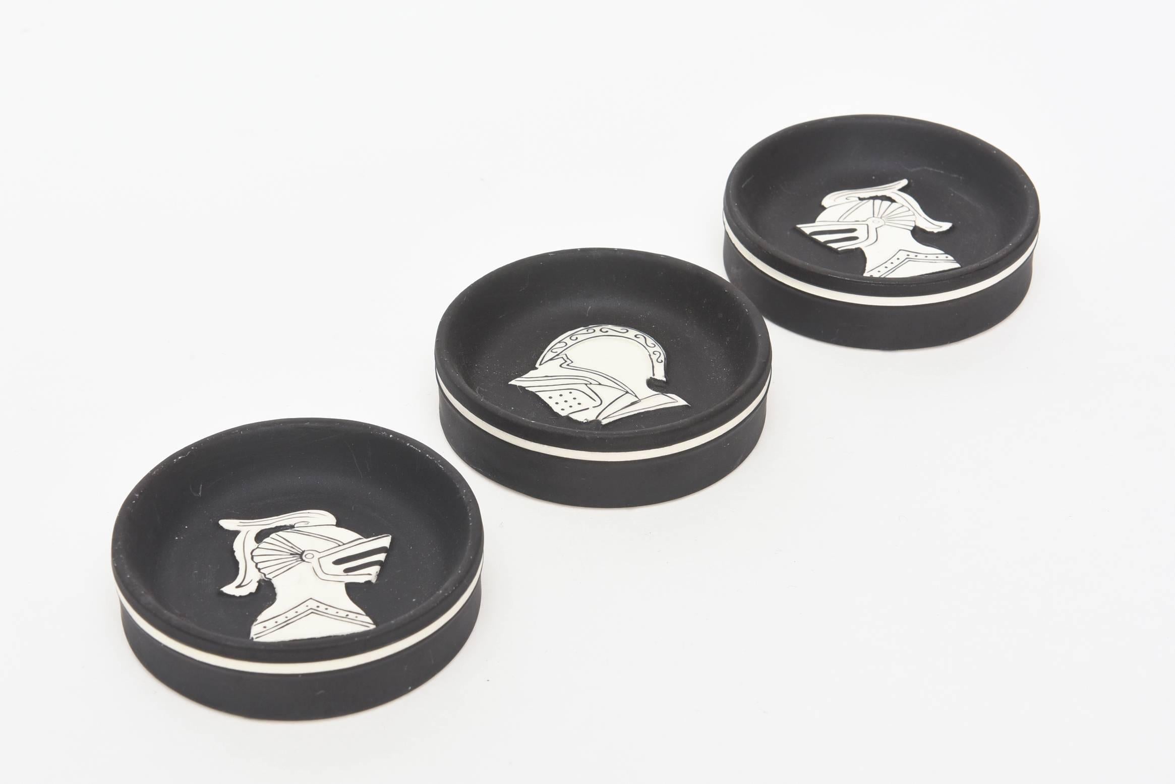 These graphic and interesting vintage German porcelain small dishes/objects are the subject matter of 3 different knights faces. The white porcelain face is raised with black drawings. The matt black porcelain bottom is outlined with white around